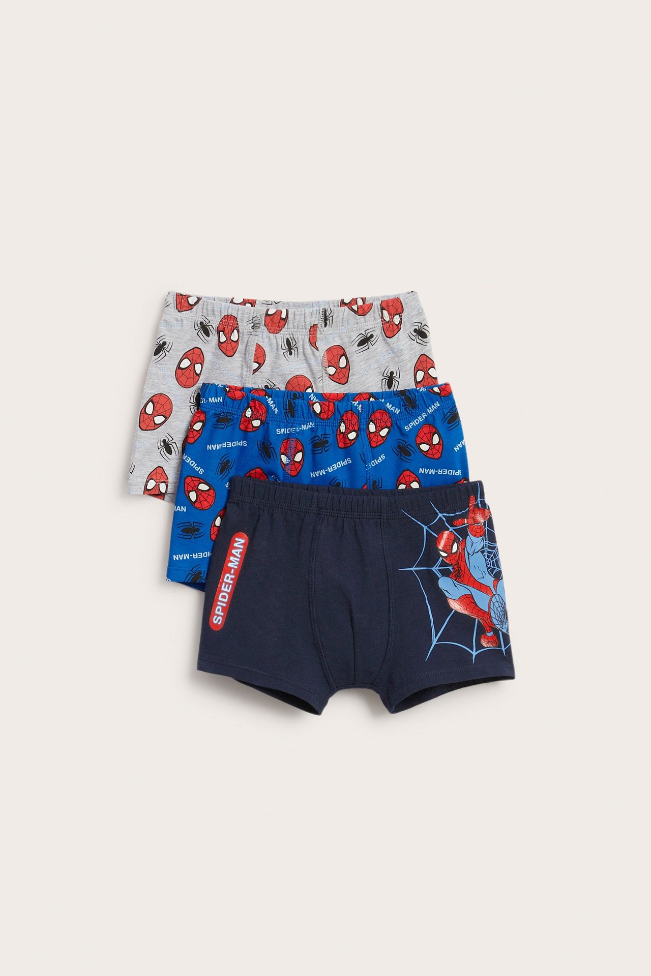 Framifrån tre barns boxerkalsonger i bomull, mörkblå, blå och ljusgrå med Spindelmannen-tryck.