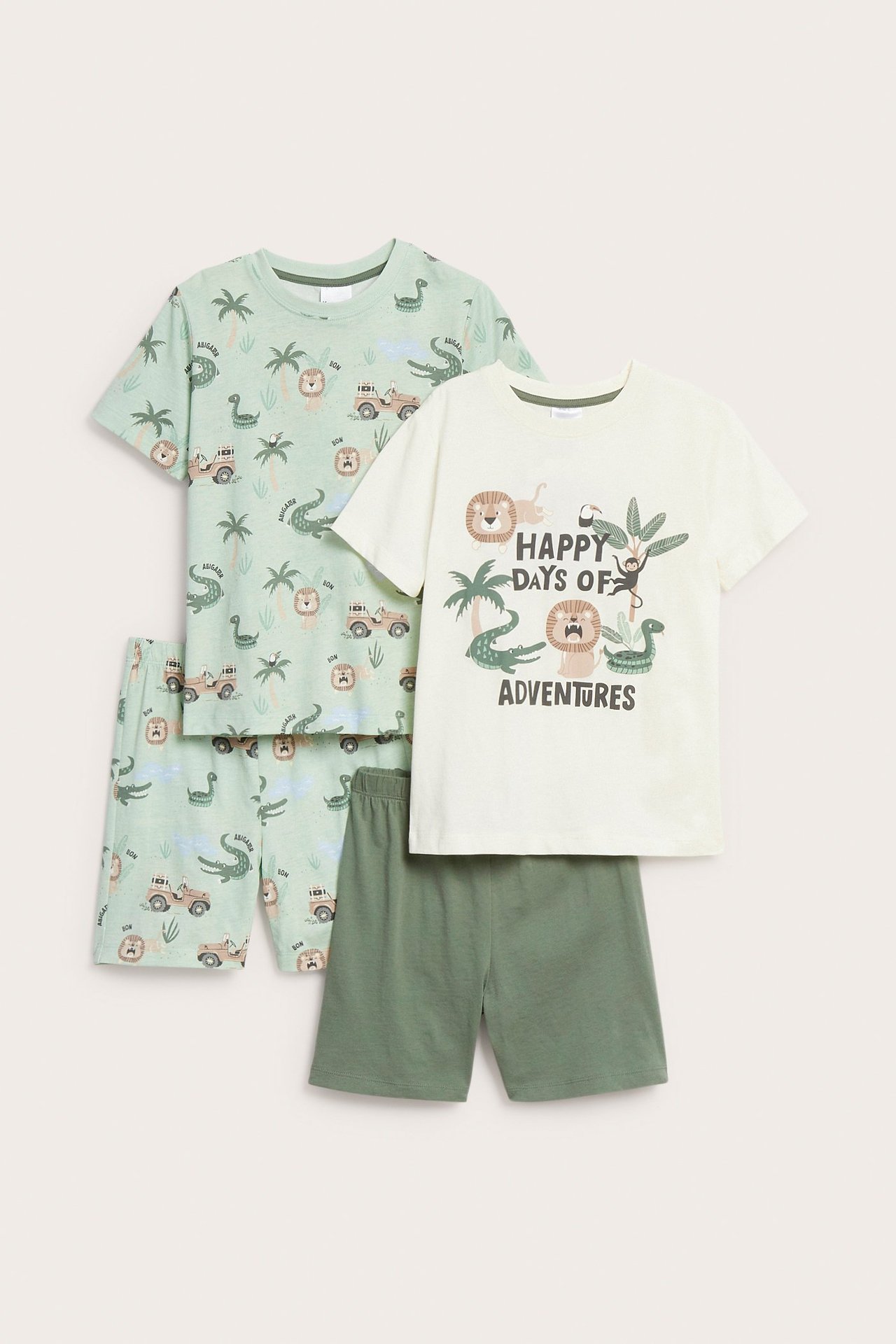 Widok z przodu, dwie piżamy dziecięce z krótkim rękawem. Jedna z nadrukiem na topie ecru i zielonymi szortami, druga zielona w całości we wzory.