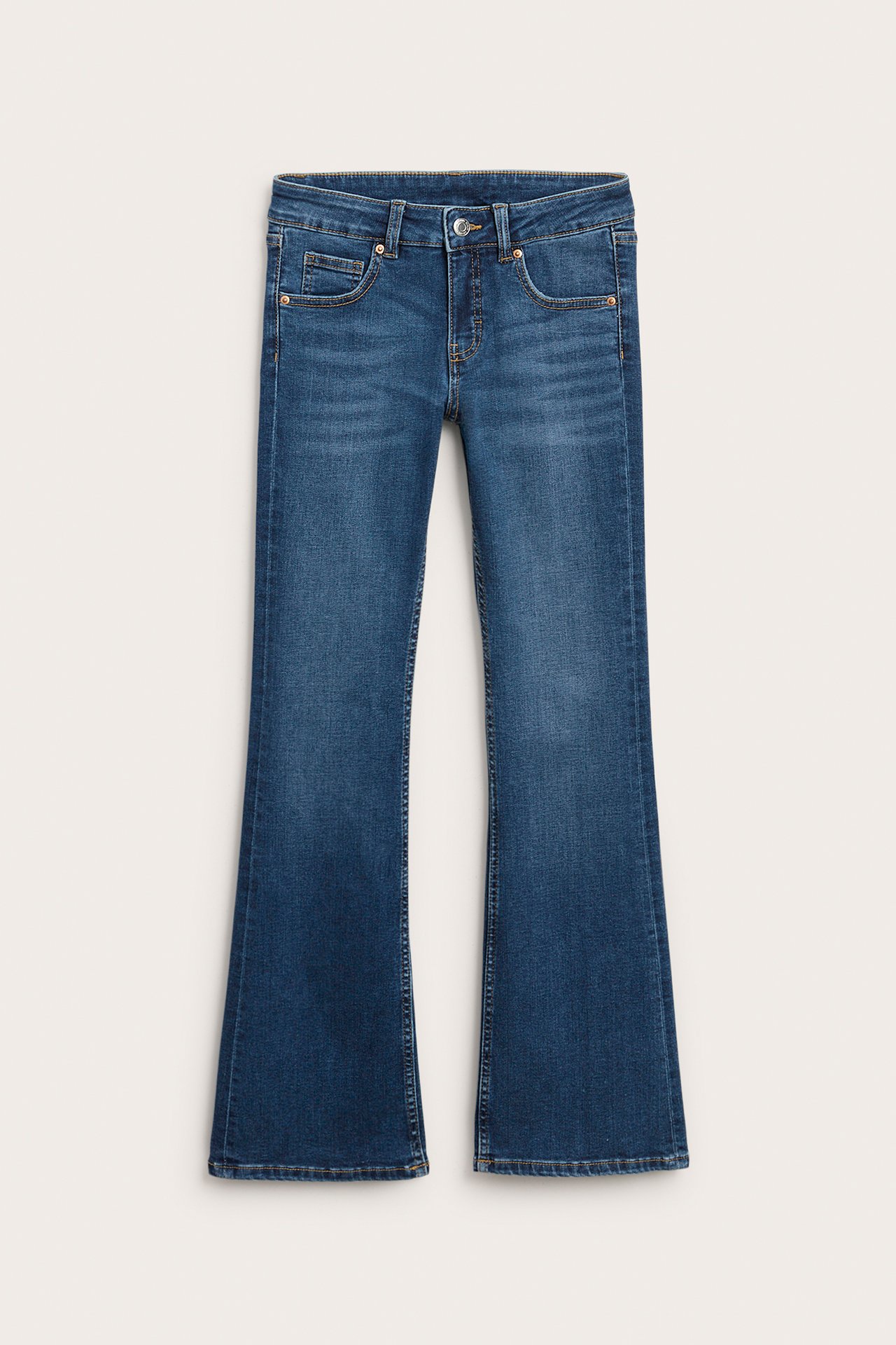 Framifrån mörkblåa bootcut jeans med låg midja, knapp och dragkedja.