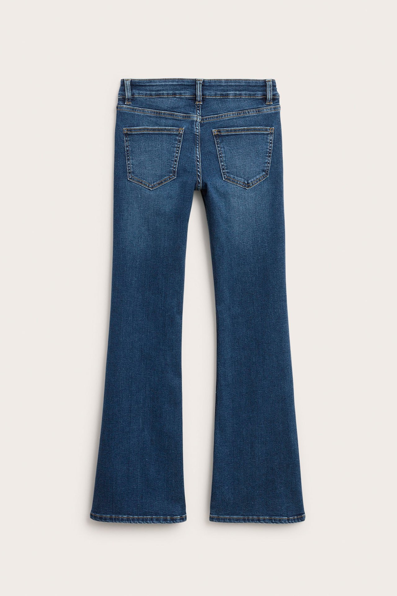 Bakifrån av mörka bootcut jeans i denim för barn, med låg midja och bakfickor.