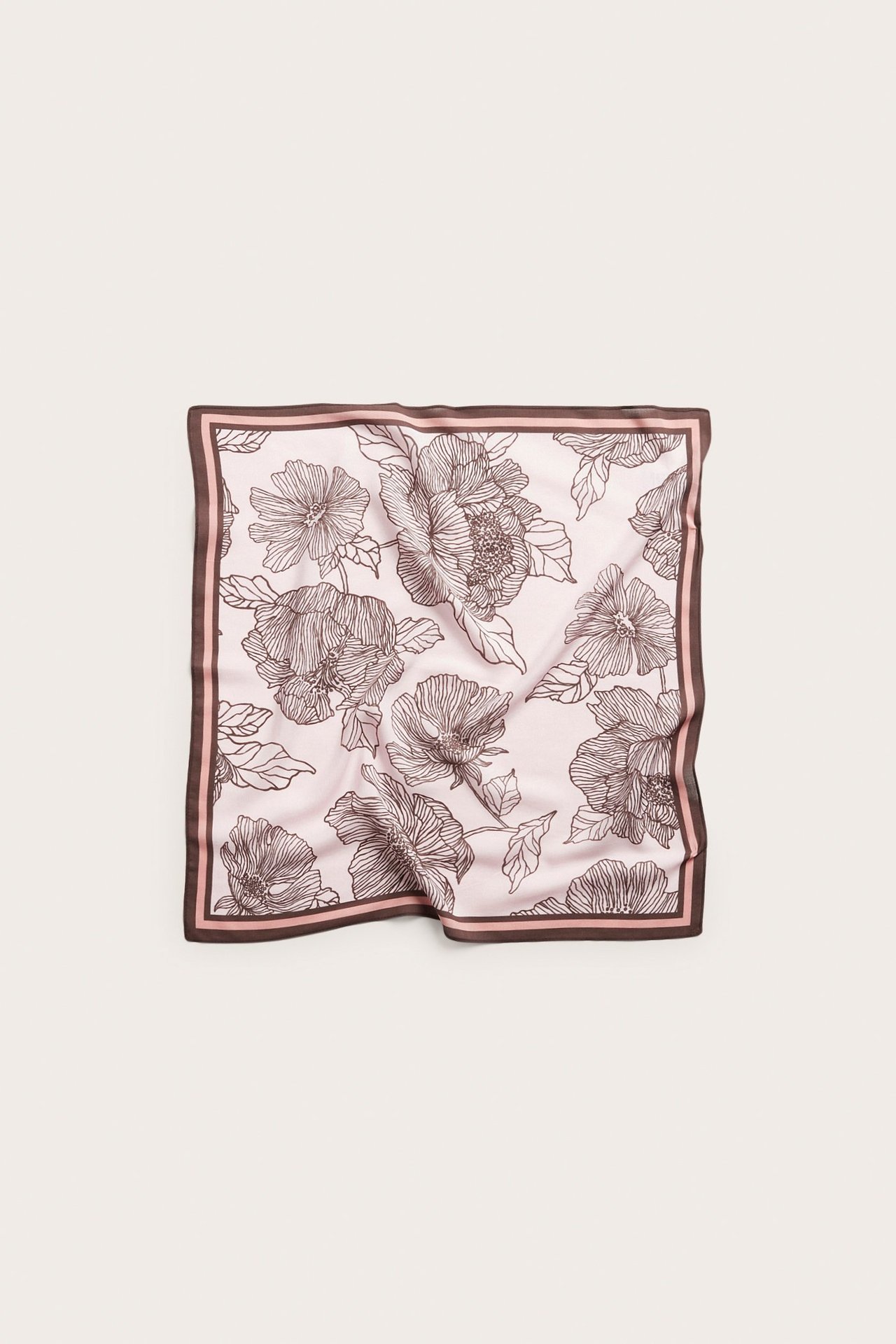 Edestä näkymä vaaleanpunaisesta neliöhuivista, jossa tummanruskea kukkakuvio ja raidallinen reuna.