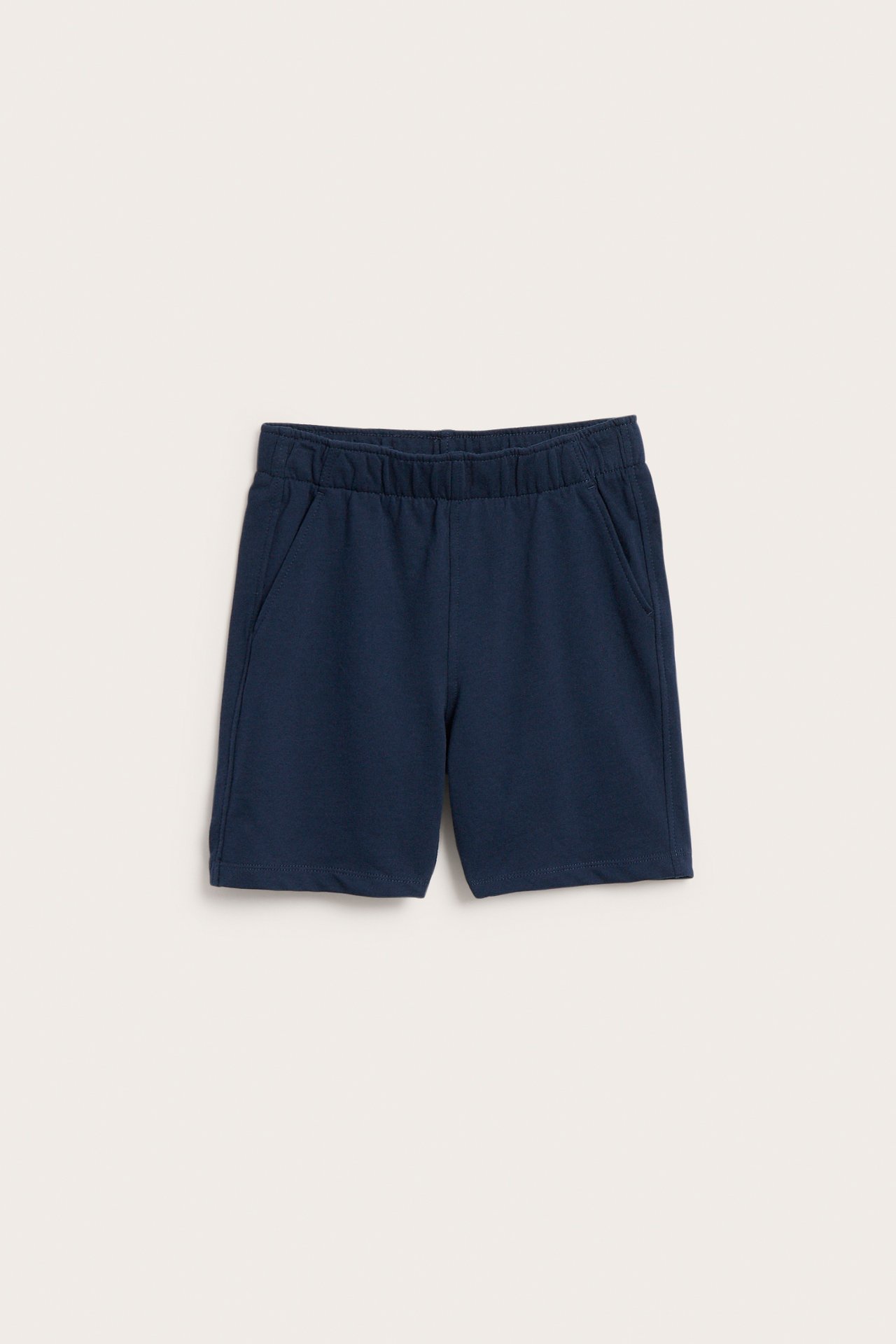 Frontvy av enfärgade mörkblå mjukisshorts i bomull för barn med resårmidja och sidfickor.