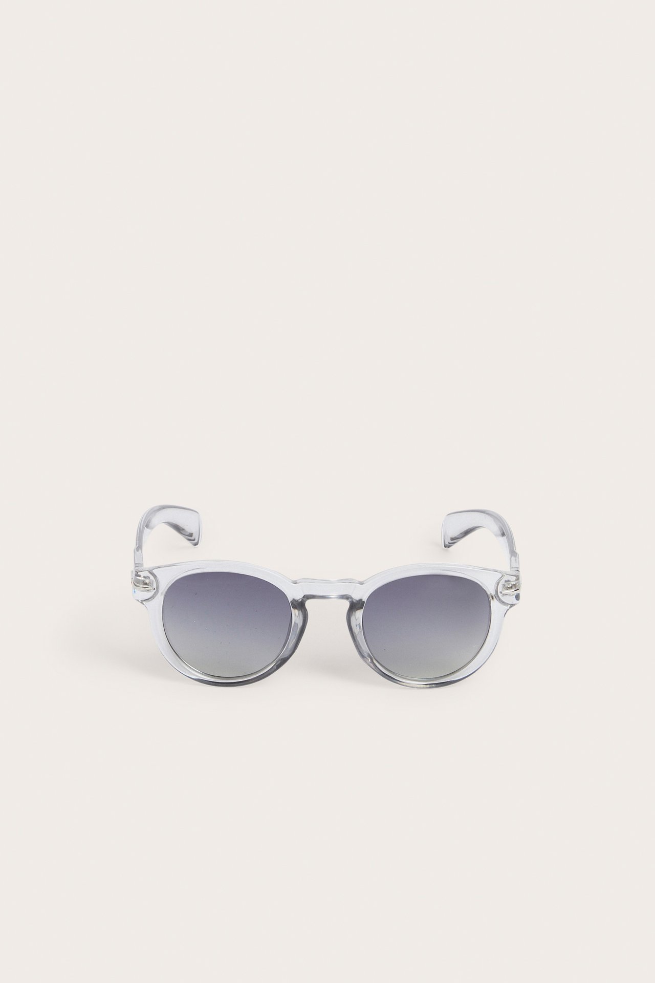 Frontvisning av runde, gjennomsiktige grå plast-solbriller med mørkegrå glass.
