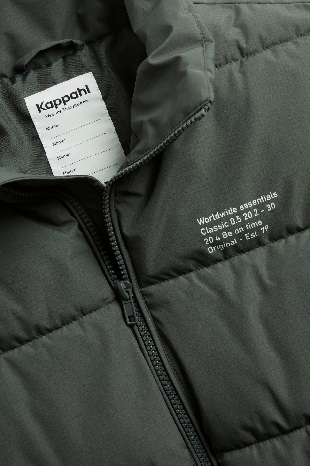 Lähikuva mustasta lasten toppaliivistä, jossa on teksturoitu kangas, pystykaulus ja etuvetoketju.