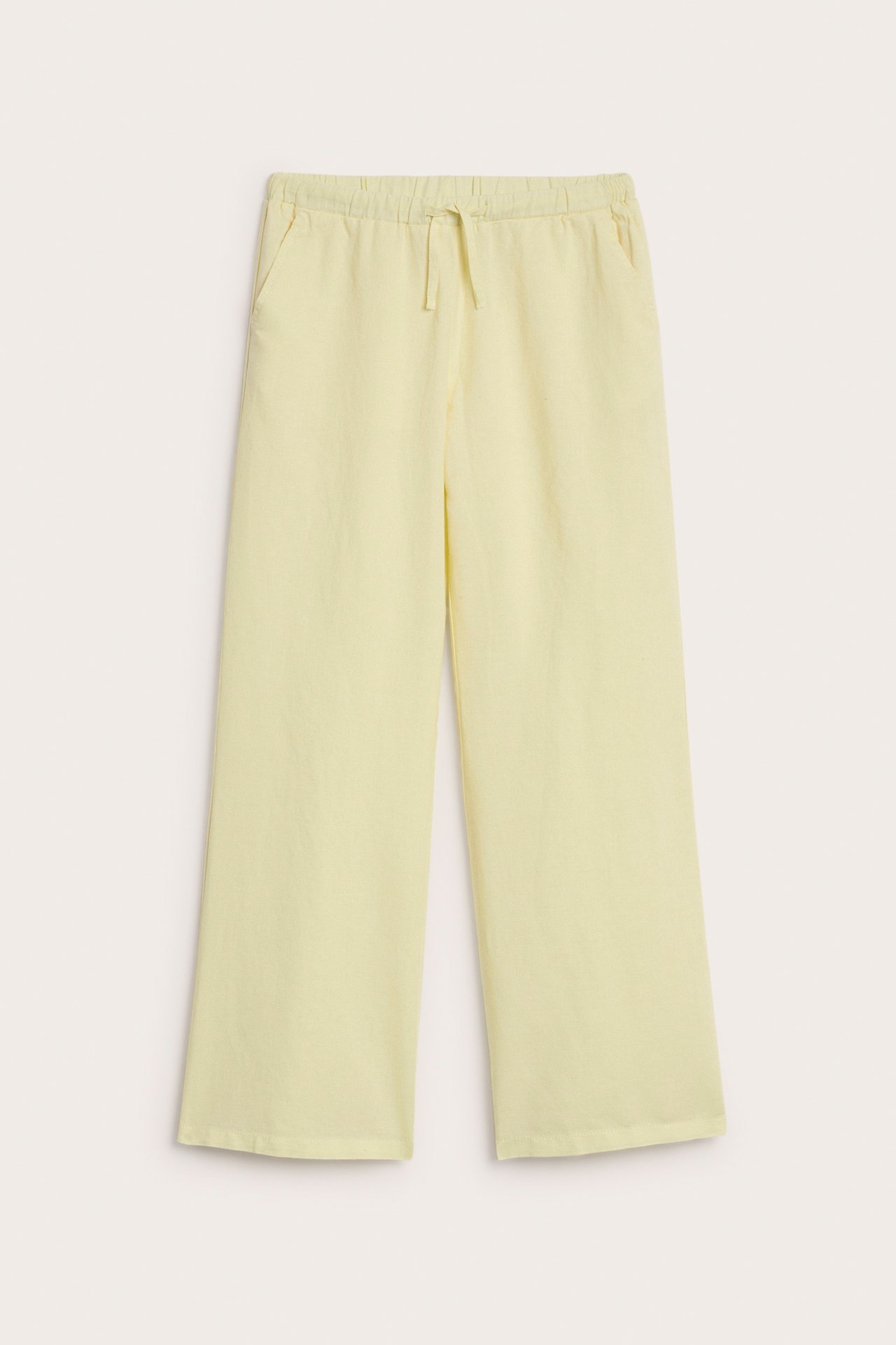 Frontbilde av lysegule linbukser med elastisk snøring i midjen og frontlommer.