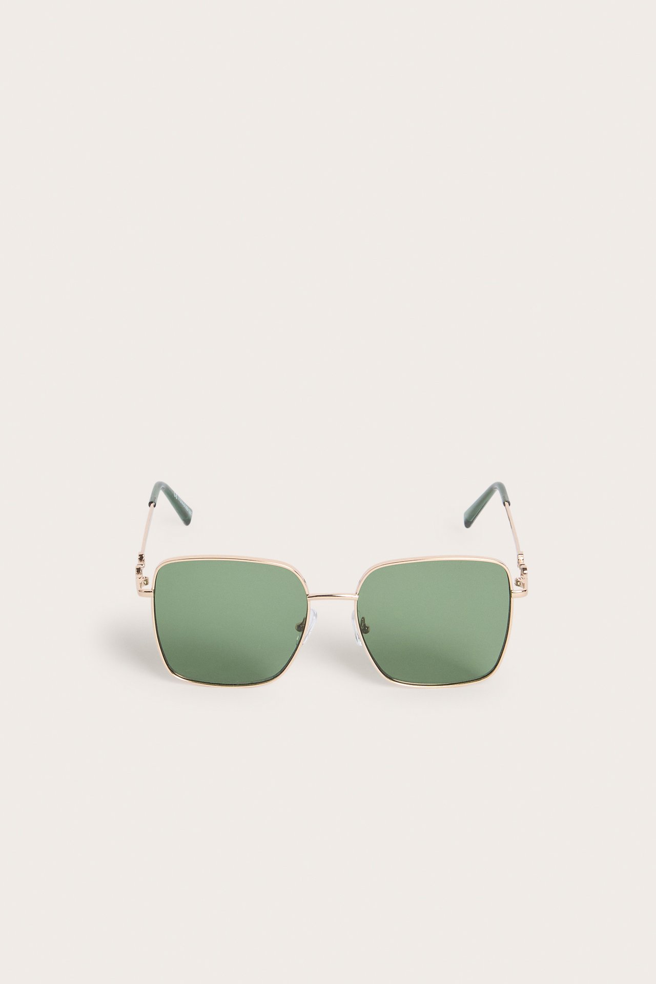 Frontvy av guldfärgade solglasögon med metallbågar och fyrkantiga gröna linser.