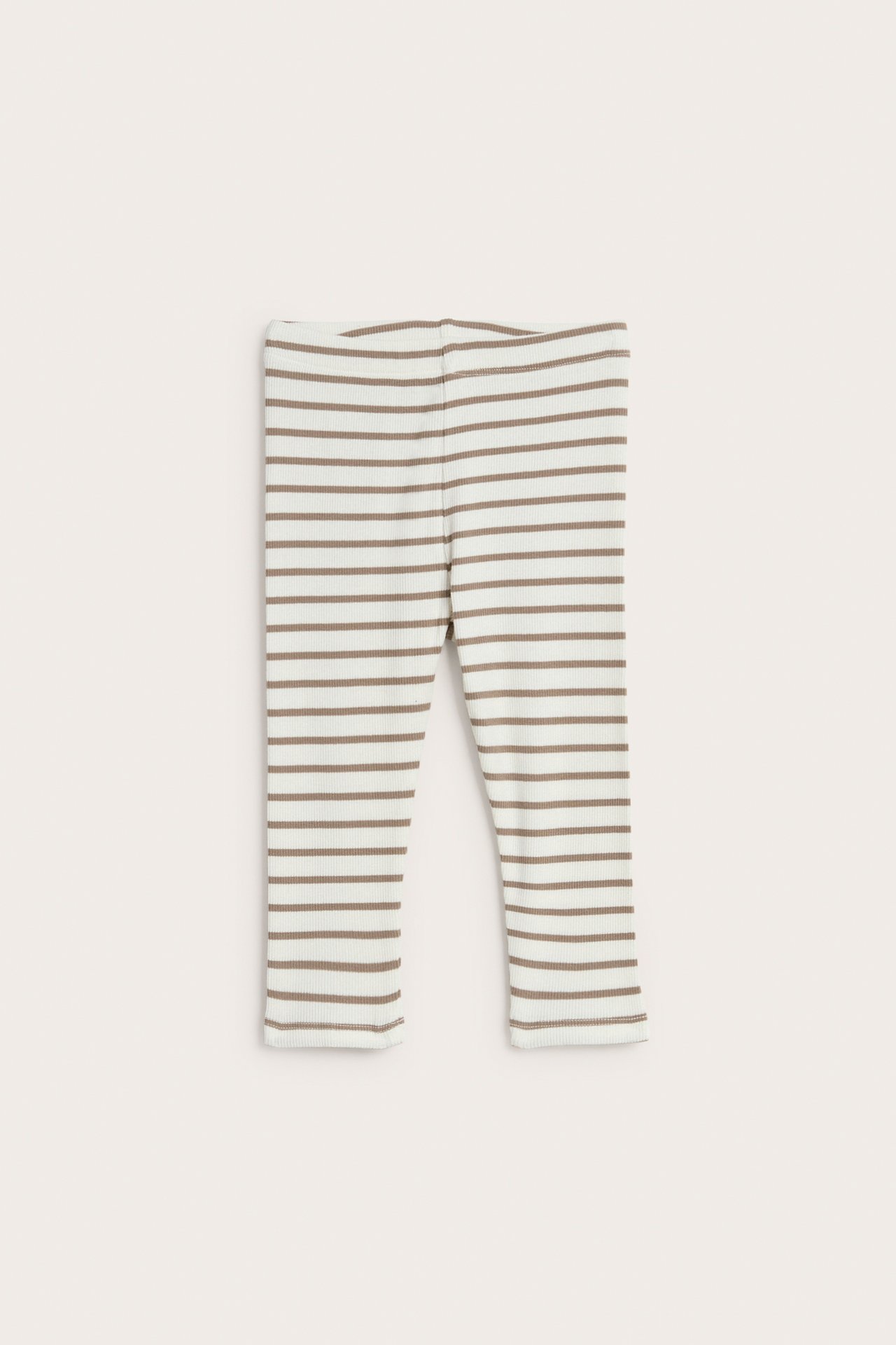 Framifrån: offwhite ribbade babyleggings med mjuk resår i midjan och bruna ränder.