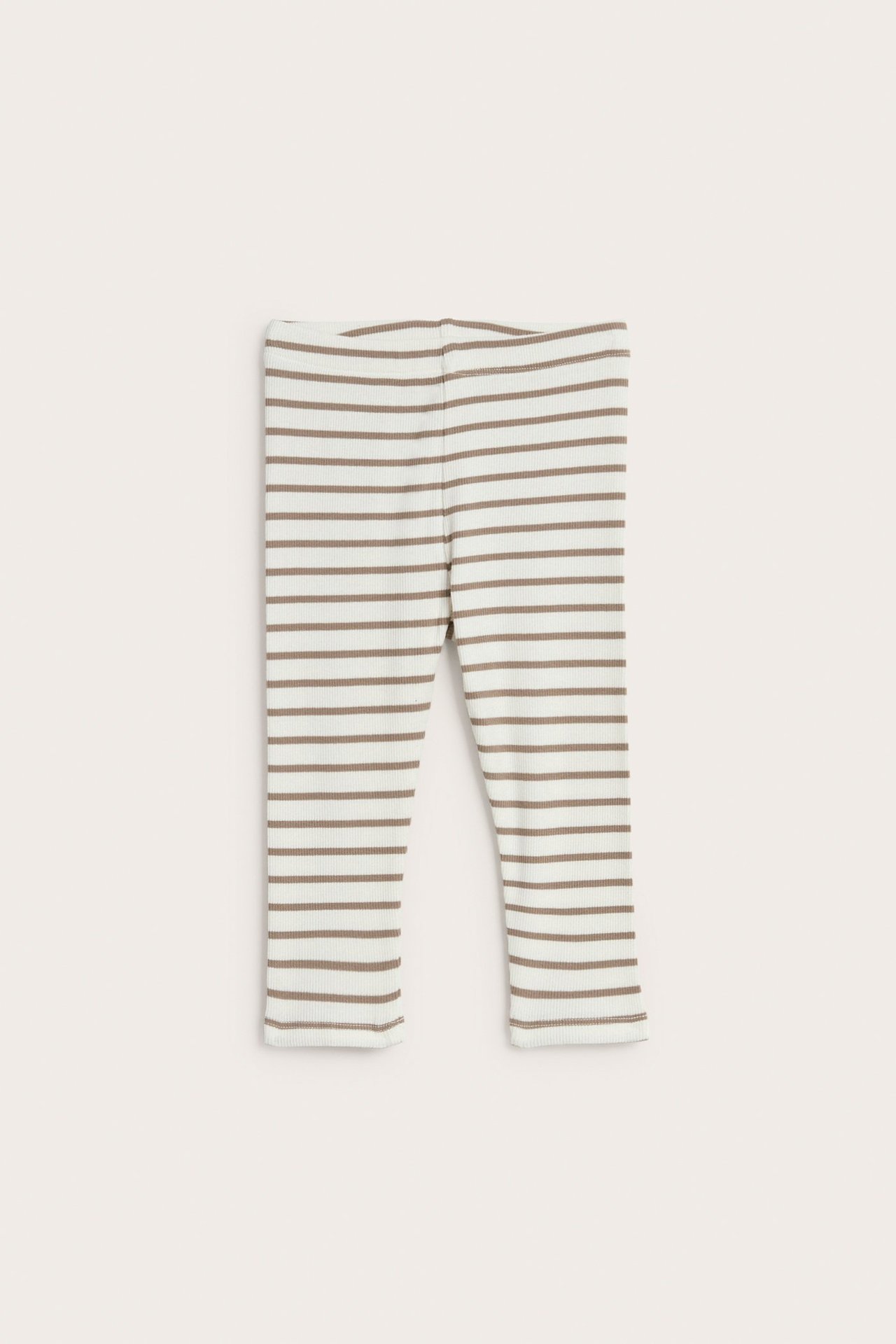 Widok z przodu: ecru prążkowane legginsy niemowlęce z miękką elastyczną talią i poziomymi brązowymi paskami.