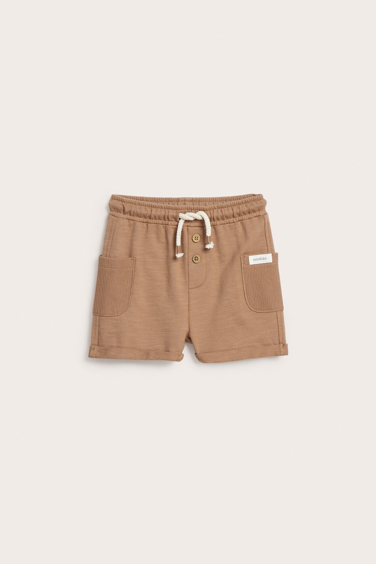 Brązowe szorty z dzianiny slub z prążkowanymi kieszeniami bocznymi, podwiniętymi nogawkami, elastyczną talią, sznurkiem i guzikami.