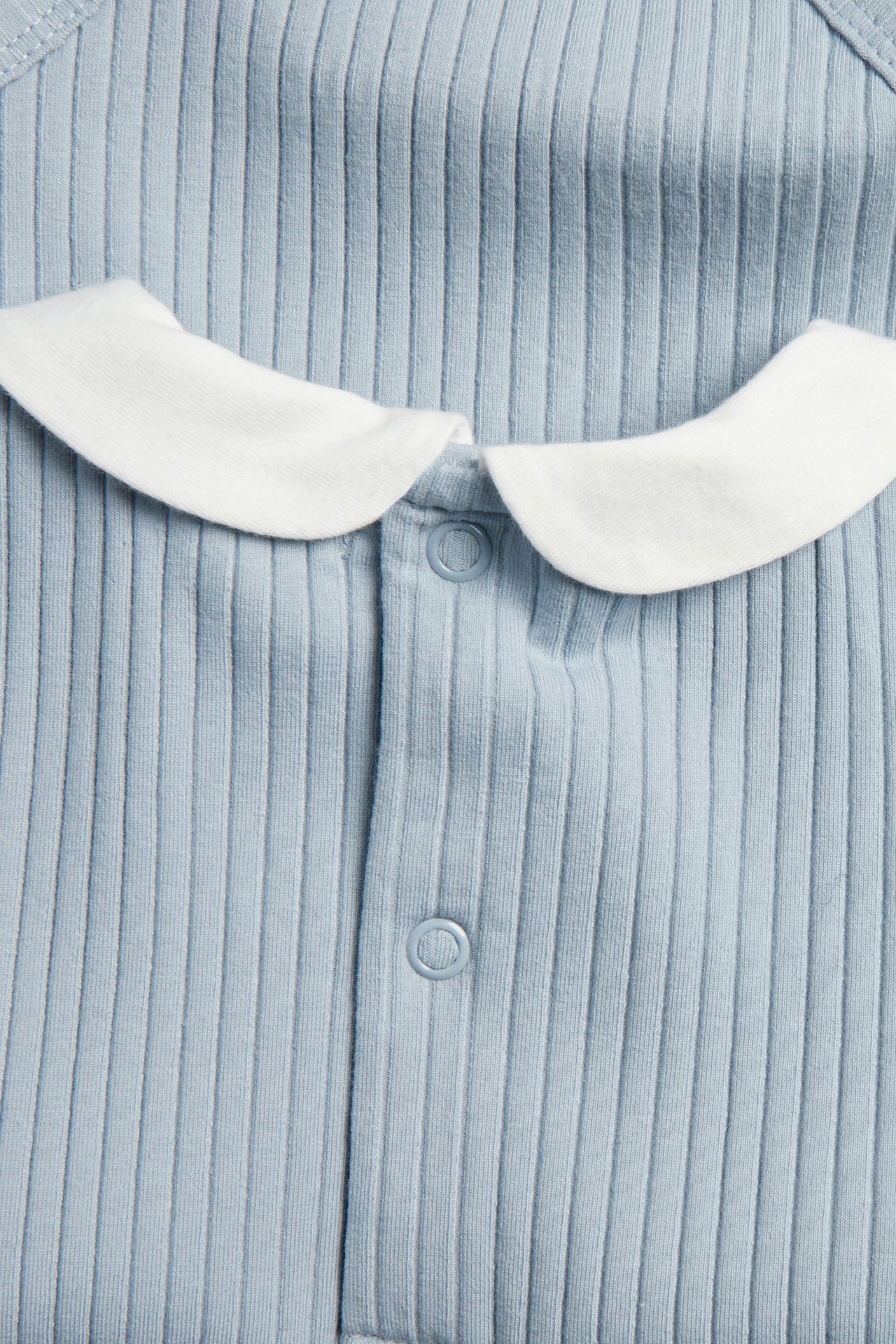 Zbliżenie niebieskiego prążkowanego body niemowlęcego z białym kołnierzykiem i zatrzaskami.