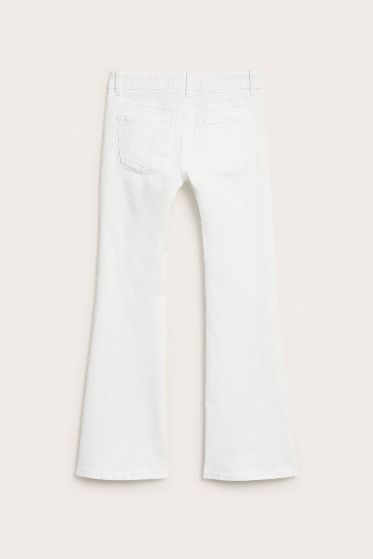 Bakside av hvite lavt liv bootcut jeans i bomullsblanding, med to baklommer.