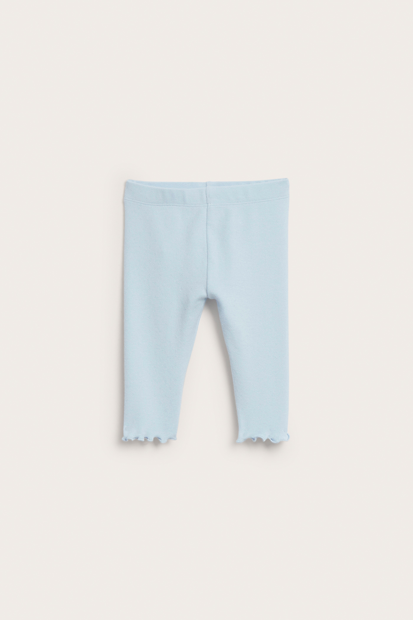 Edestä, vaaleansiniset pointelle-neulotut vauvan leggingsit, joissa on picot-reunus lahkeensuussa.