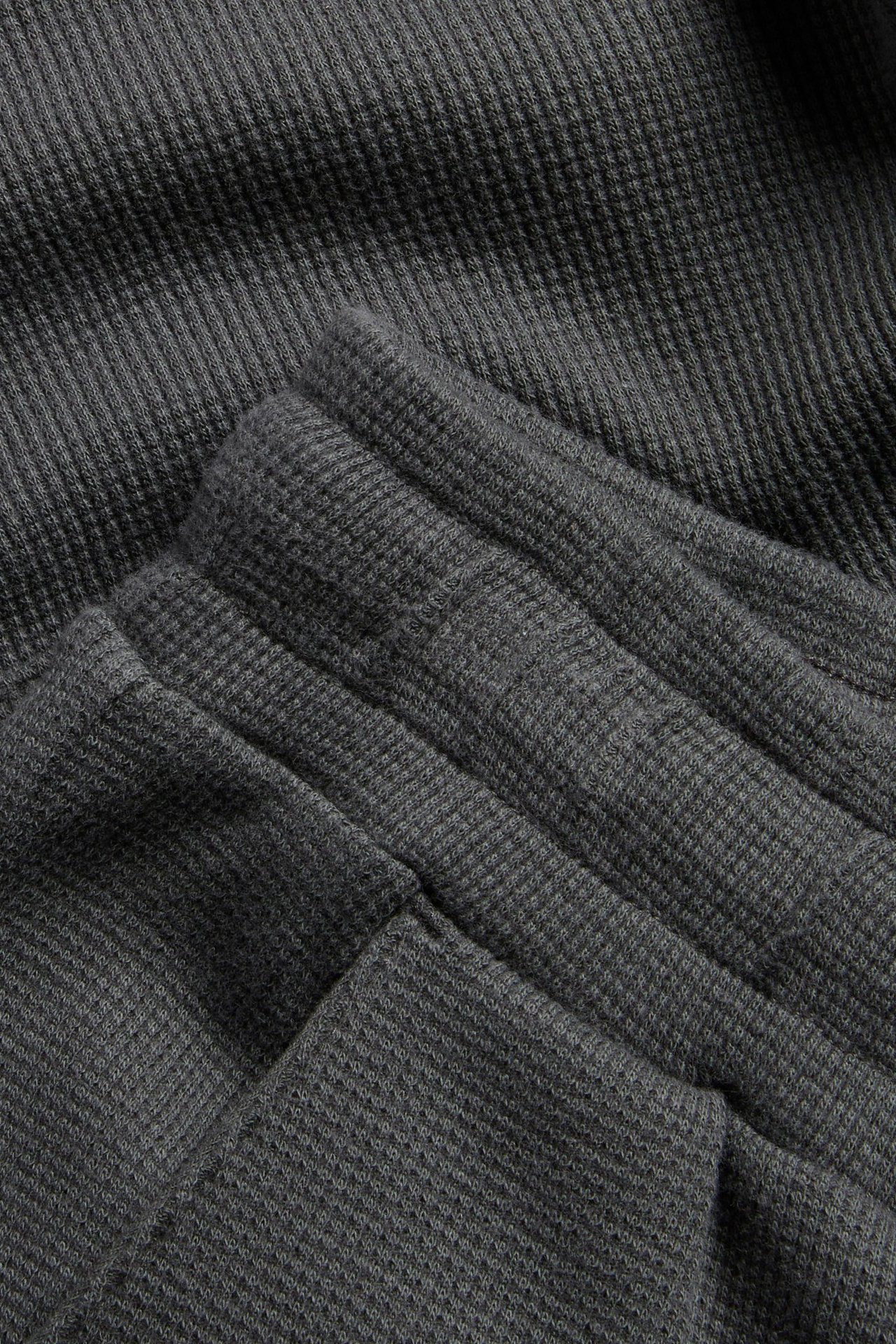 Lähikuva mustista vohvelikuvioisista puuvillashortseista, joissa on joustava vyötärö.