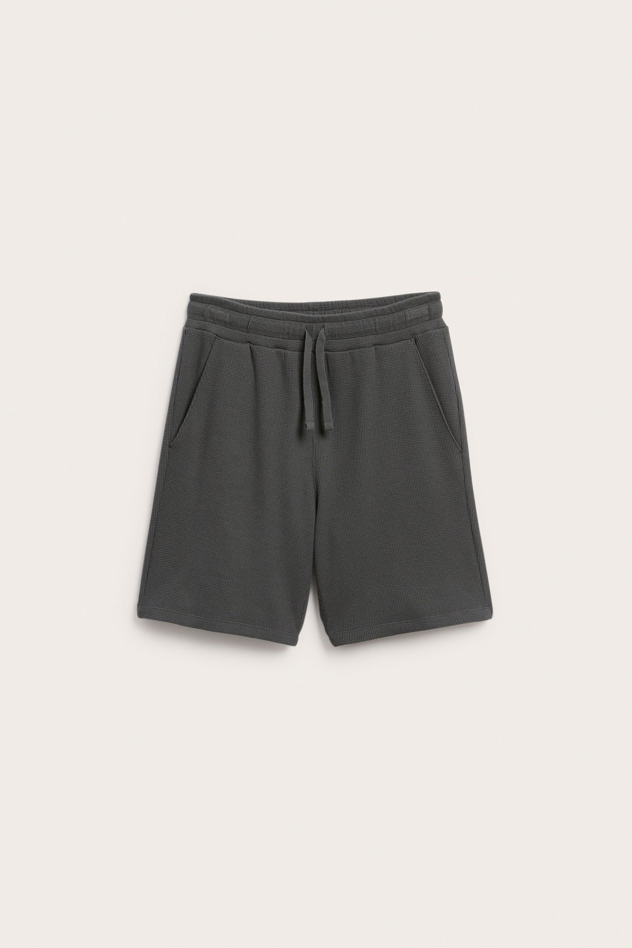 Front: Mørkegrå vaflet bomullsshorts med elastisk linning, snøring og sidelommer.