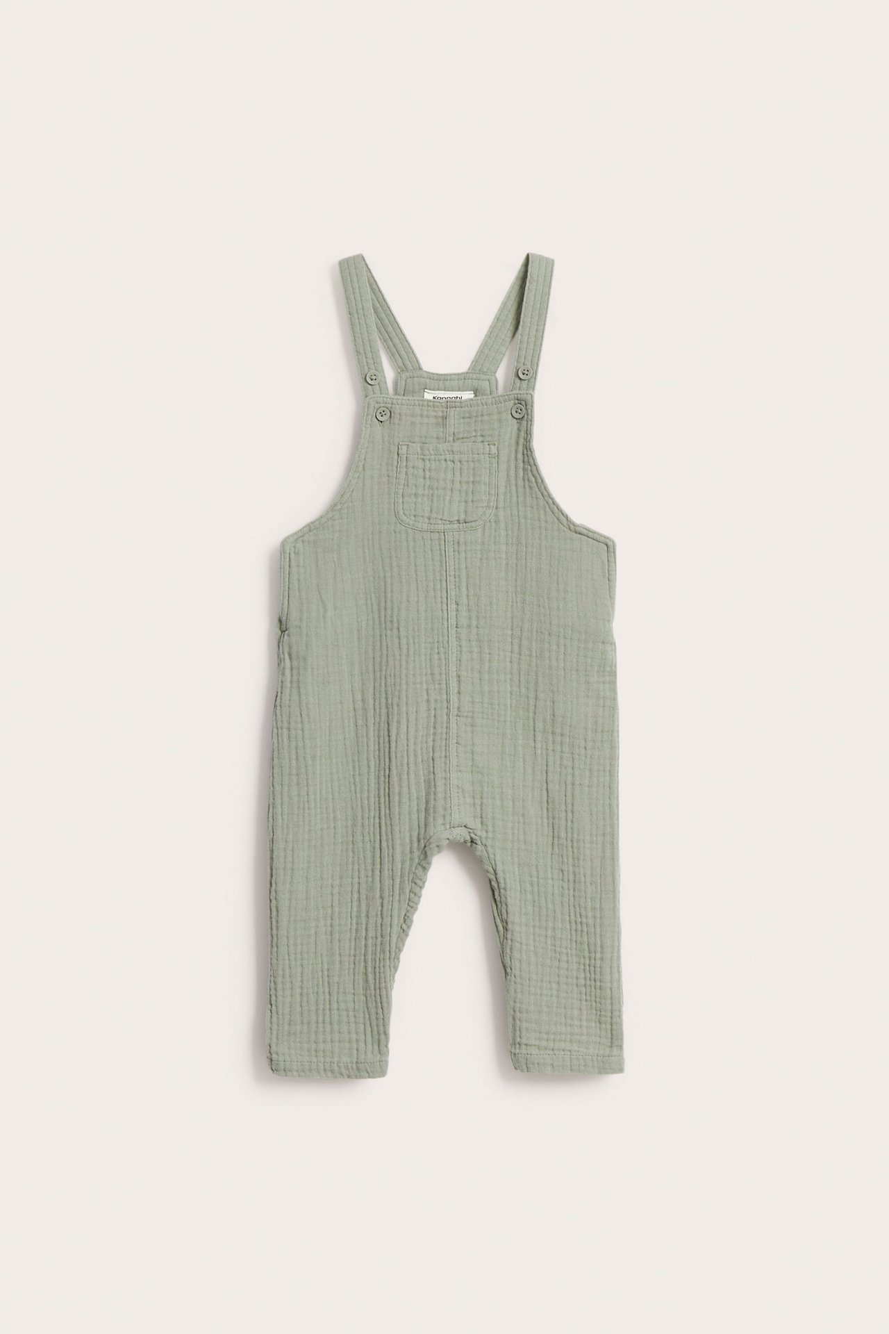 Frontutsikt: mørkegrønne baby-selebukser i muslin med knapper på seler og trykknapper i siden.