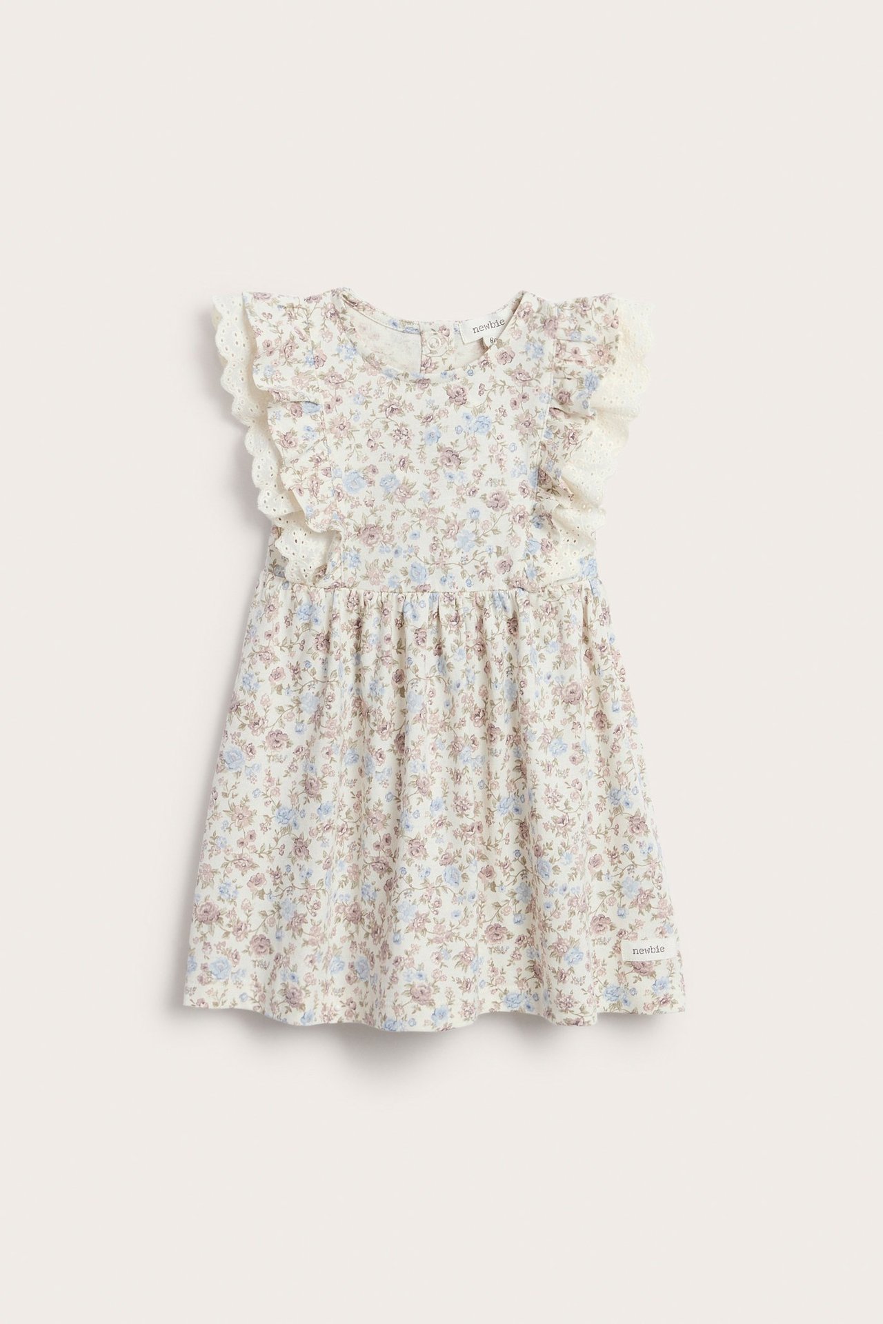 Frontbilde av en offwhite babykjole i blomstret jersey med volang og blondekant.