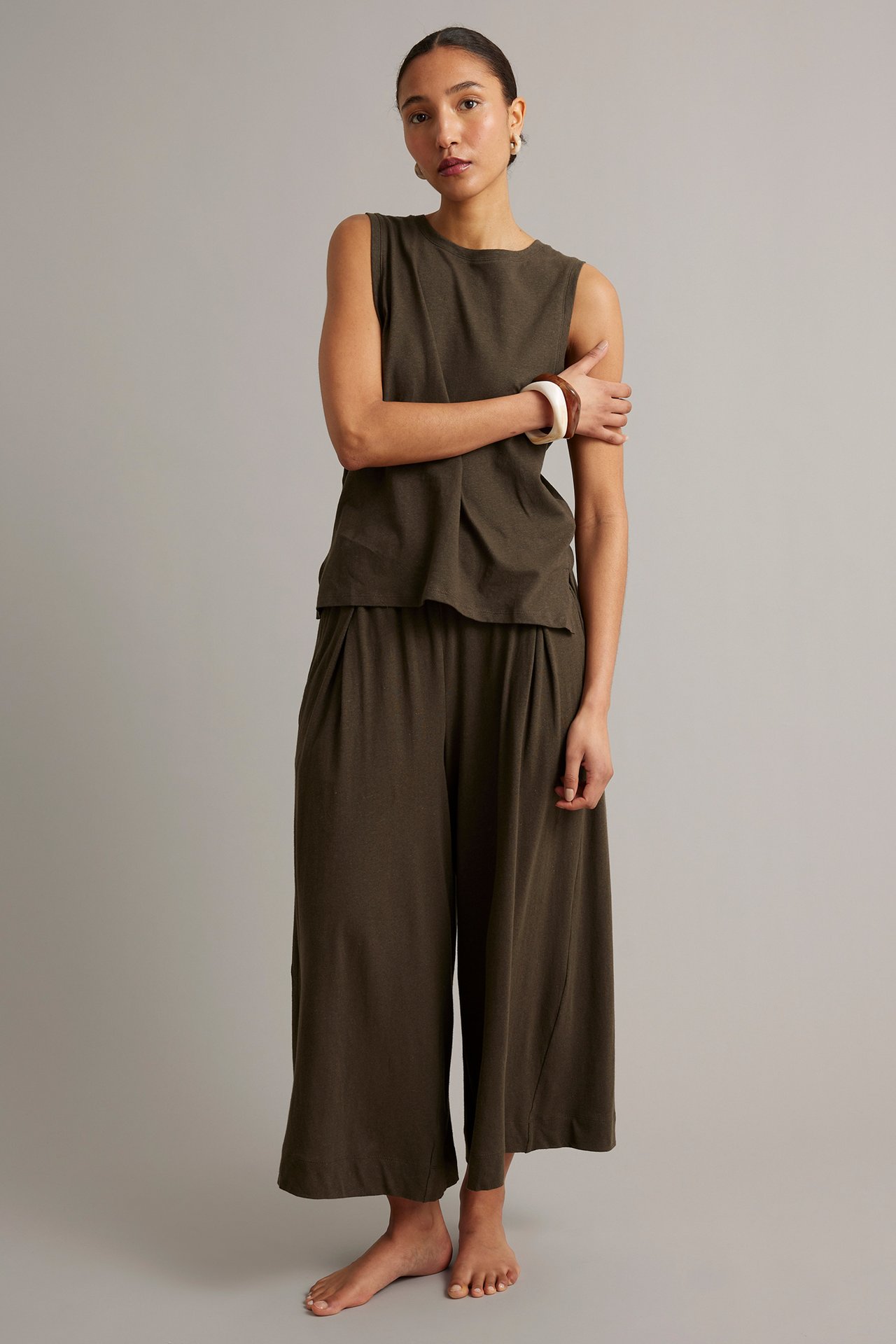 Framifrån, kvinna i brun linneblandningstopp och matchande vida culottebyxor.
