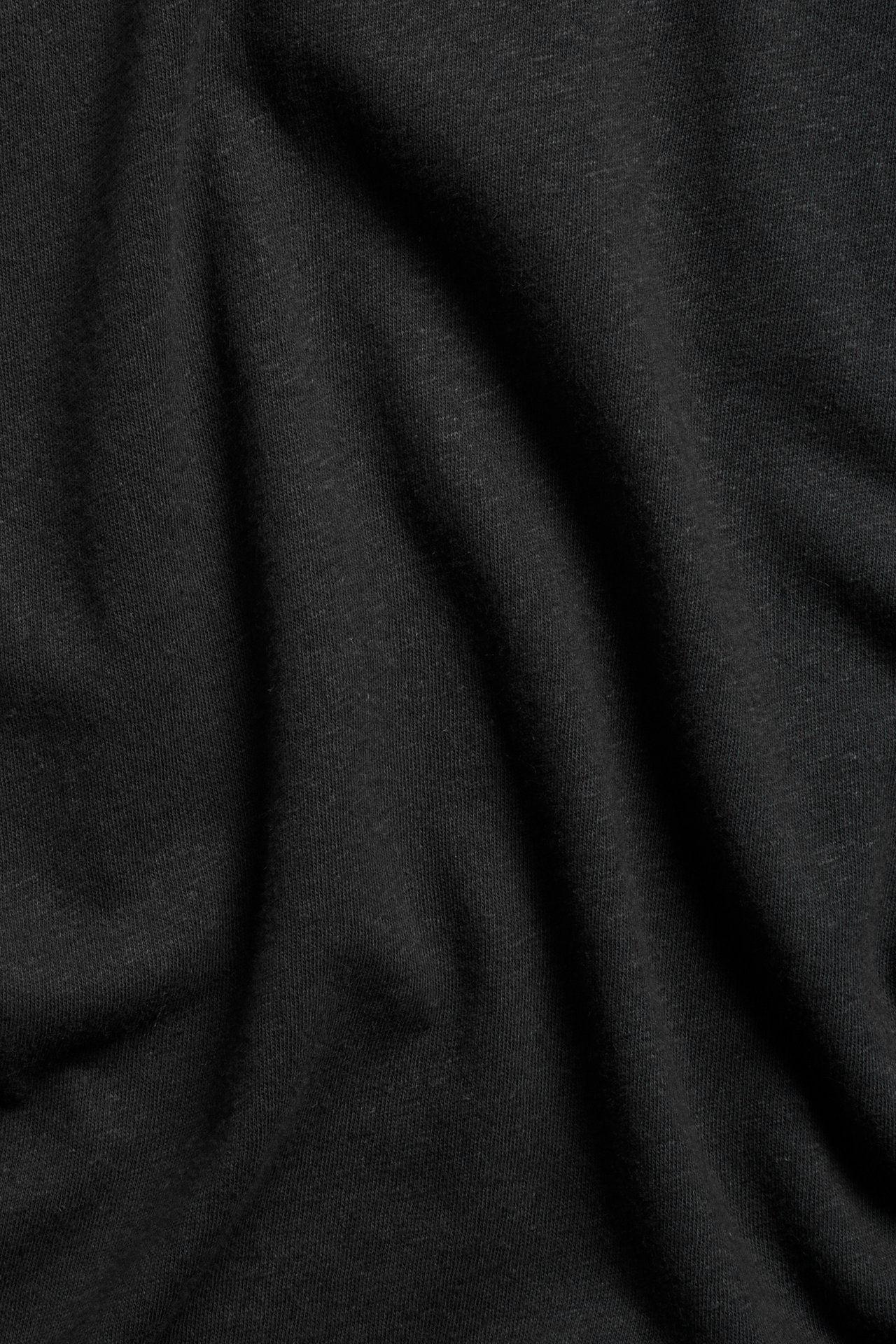 Närbild av svart tyg till tanktopp i bomull-linnemix med enfärgat mönster.