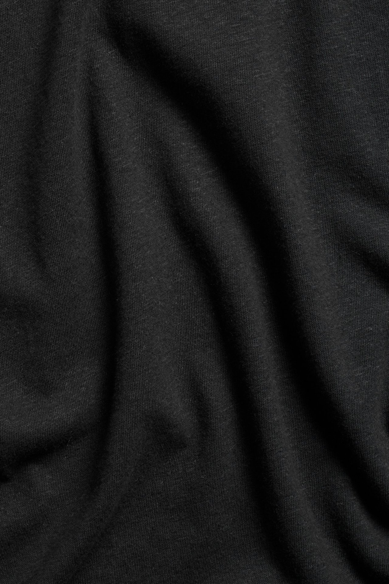 Zbliżenie czarnego materiału topu z mieszanki bawełny i lnu, gładki wzór.