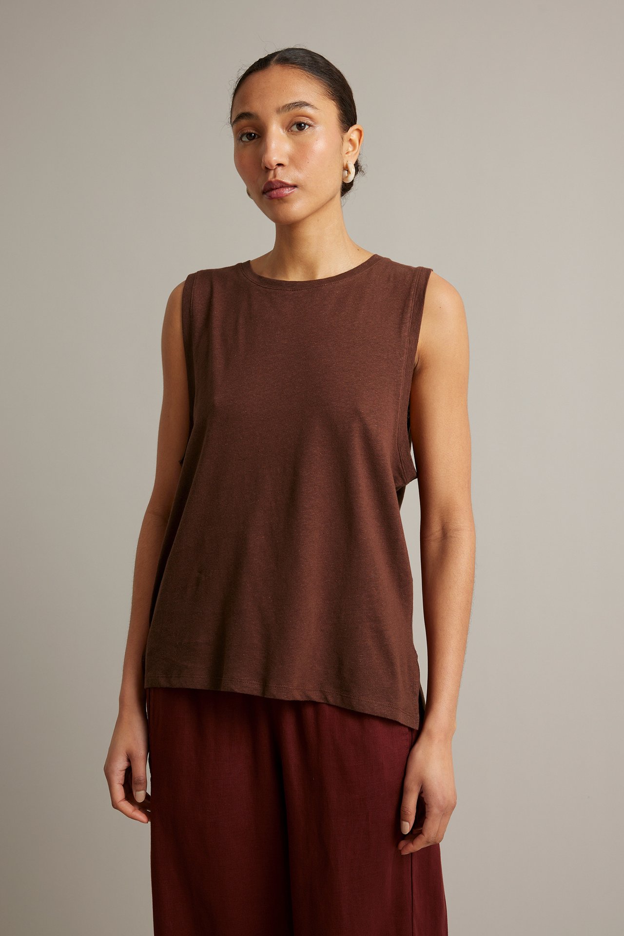 Framifrån, kvinna i löst sittande vinröd tanktop i linne-bomull och matchande culottebyxor.