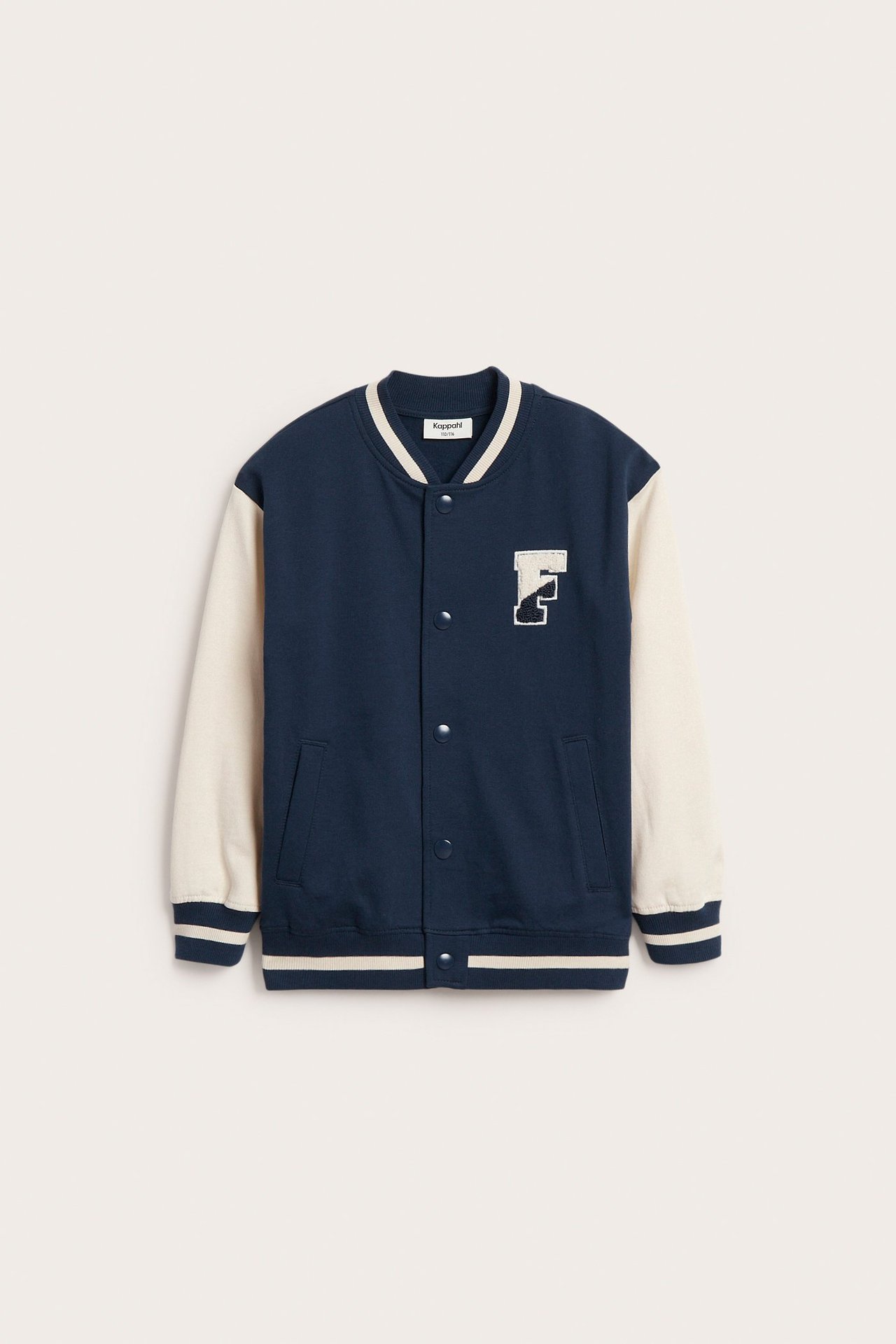 Widok z przodu: Granatowa dzianinowa kurtka bejsbolówka z ecru rękawami, zatrzaskami i aplikacją z frotte „F”.