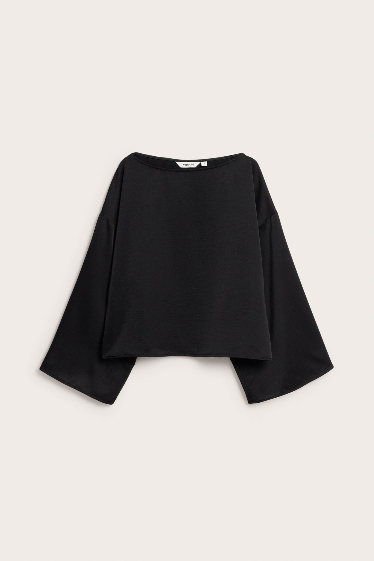 Edestäpäin, musta polyesterisatiinipusero, jossa venepääntie ja leveät hihat.