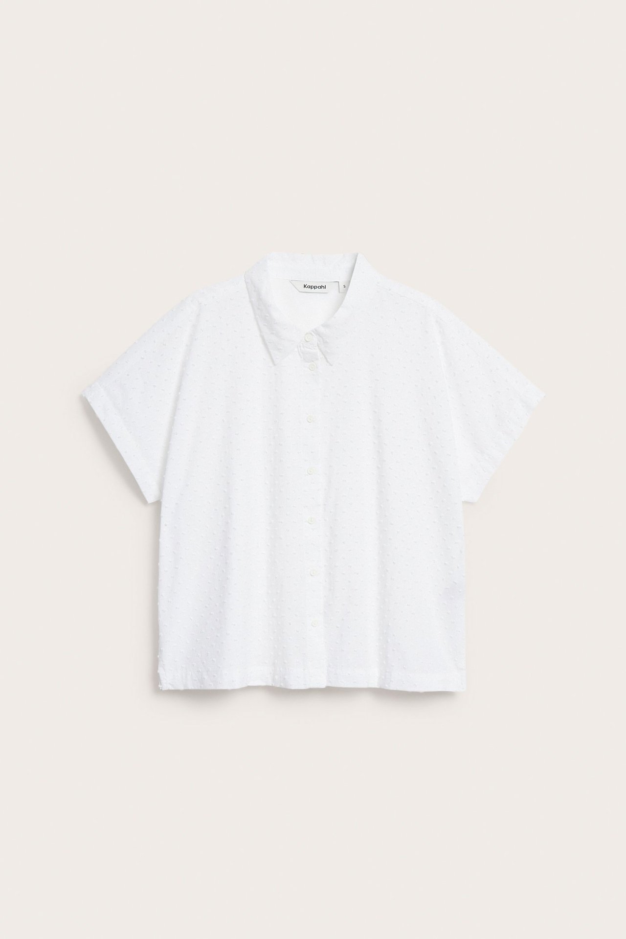 Frontvy av en vit, diskret prickig bomullsskjorta med korta ärmar och knäppning framtill.