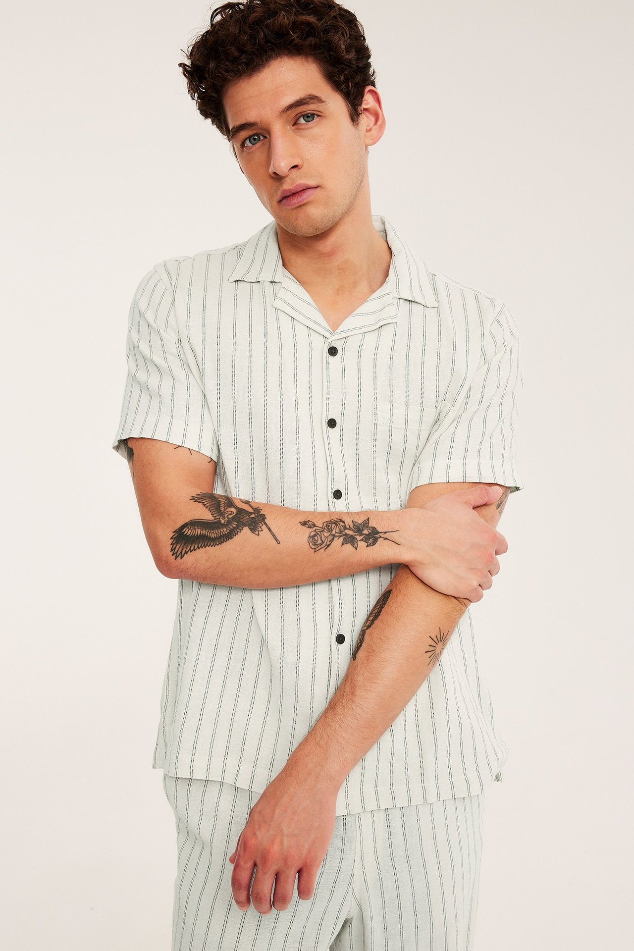 Framsida av man i ljusbeige randig resortskjorta med kort ärm i linne/viskosmix och matchande byxor.