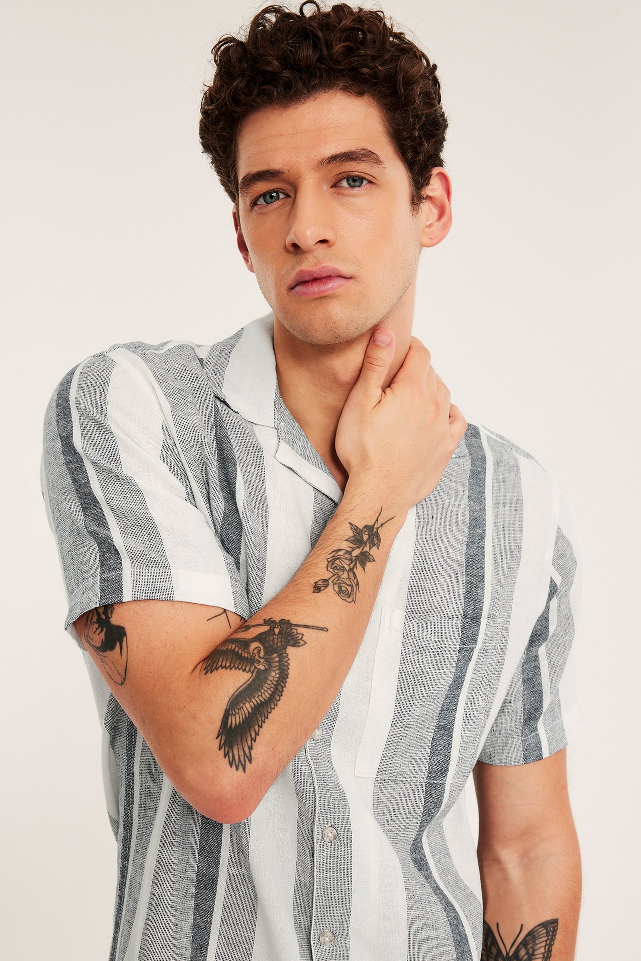 Przód: mężczyzna w pasiastym, granatowo-białym, krótkim rękawem lnianej koszuli z kieszenią na piersi.