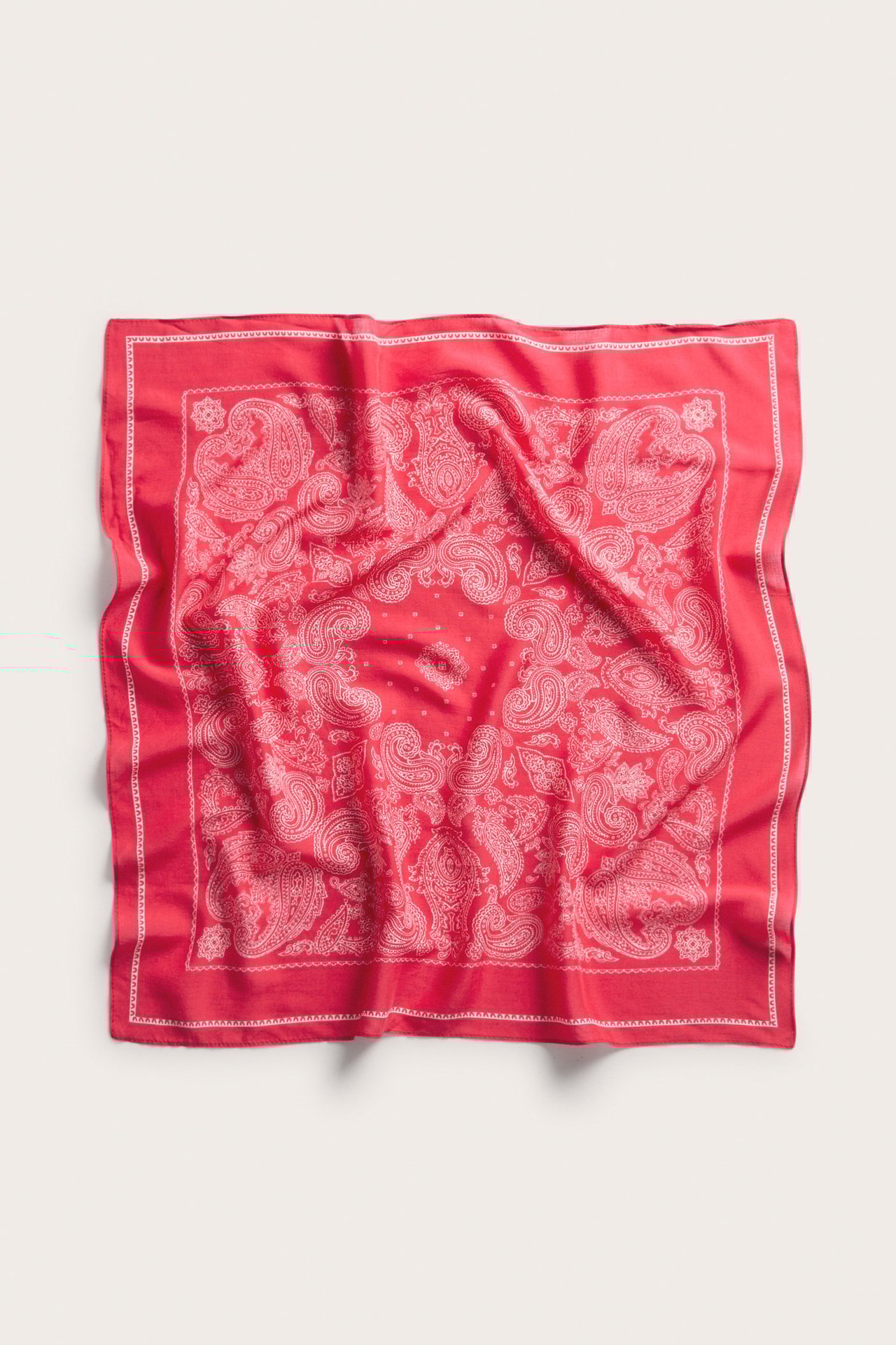Topputsikt av et rødt, firkantet paisleymønstret skjerf i lyocell- og viskoseblanding.