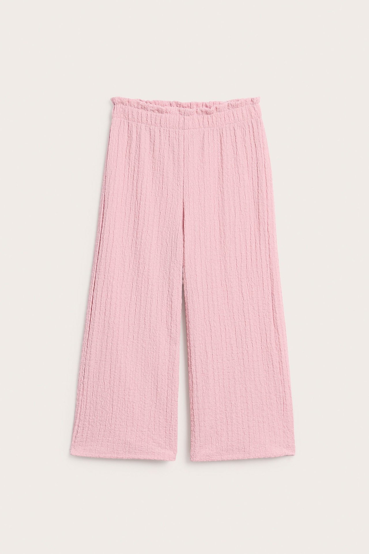 Widok z przodu: Jasnoróżowe, marszczone kuloty z szerokimi nogawkami i elastyczną talią z falbanką.