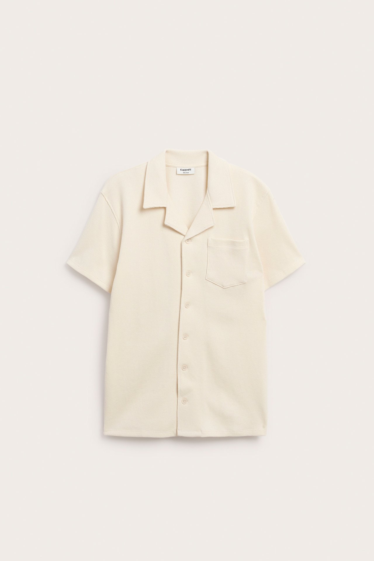 Widok z przodu: jasnobeżowa krótko rękawowa koszula z bawełny waflowej, kołnierzem resortowym, kieszenią i guzikami.