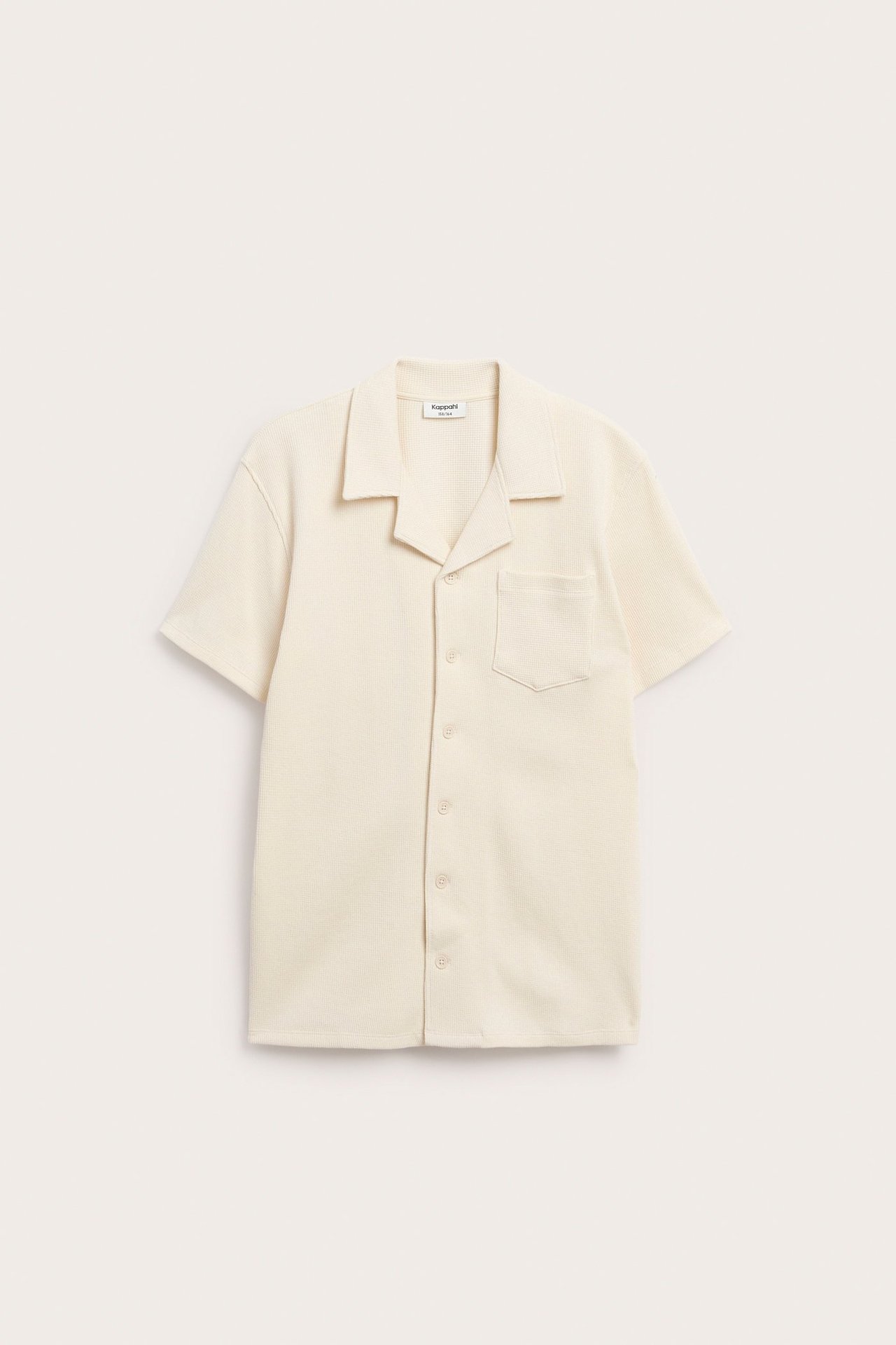 Widok z przodu: jasnobeżowa krótko rękawowa koszula z bawełny waflowej, kołnierzem resortowym, kieszenią i guzikami.