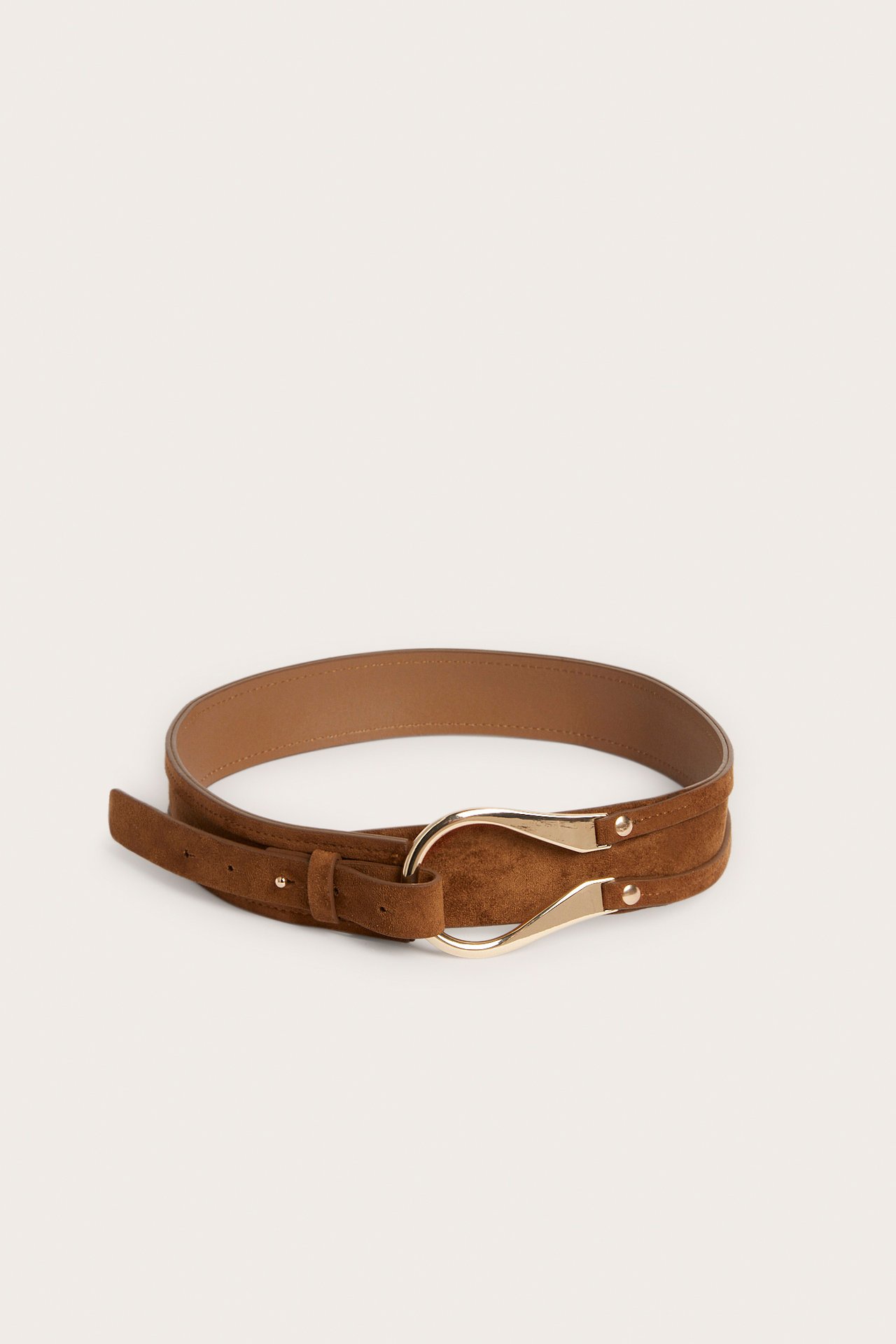 Framifrån: Ett ljusbrunt bälte i mockaimitation med ett unikt guldfärgat spänne.