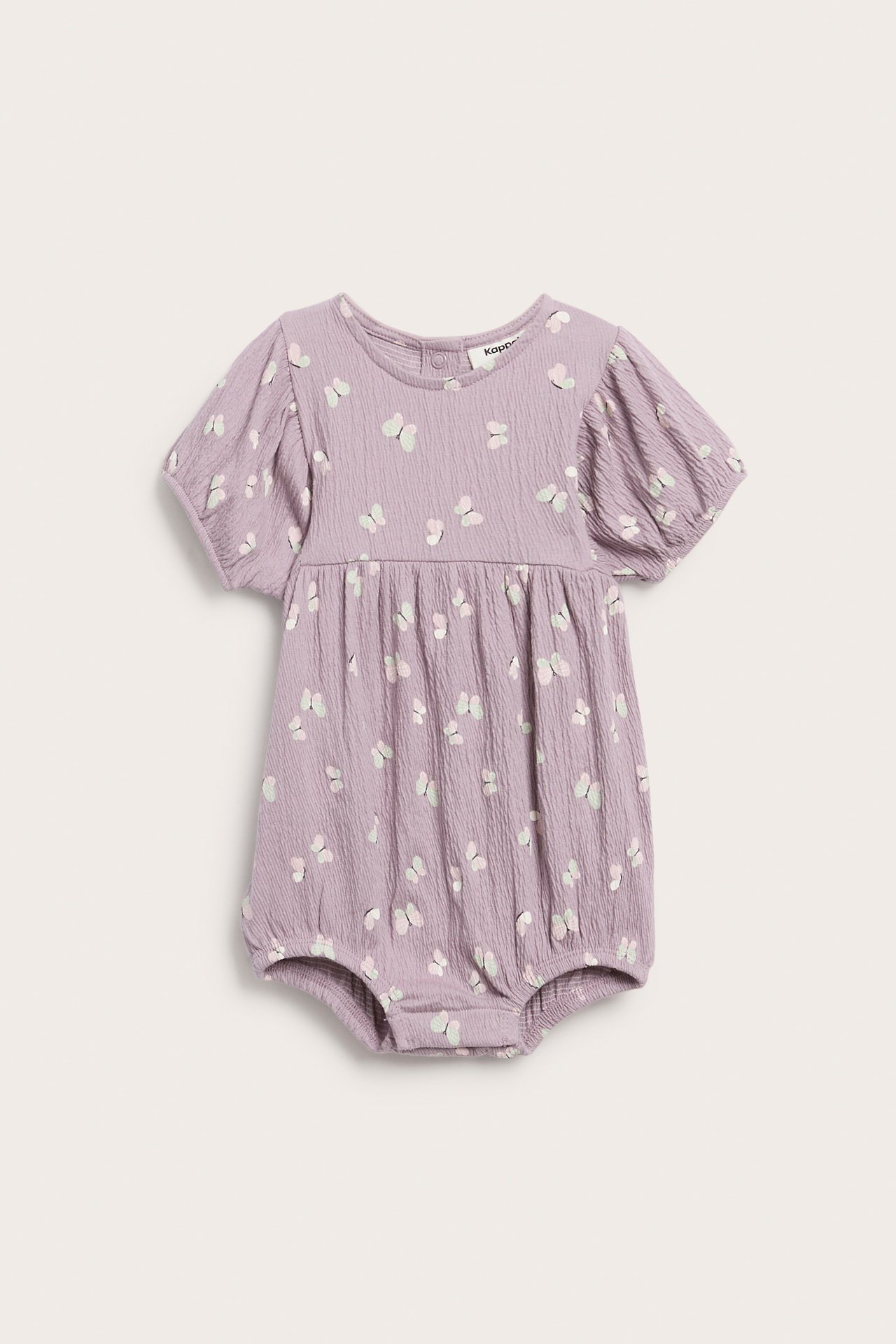 Edestäpäin, vauvan lila romper, jossa on lyhyet pussihihat ja vaalea perhoskuvio.