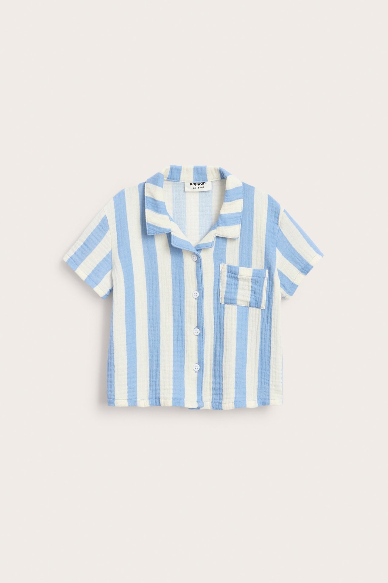 Edestä näkymä vauvan vaaleansinisestä ja luonnonvalkoisesta raidallisesta lyhythihaisesta musliinipaidasta, napeilla ja rintataskulla.