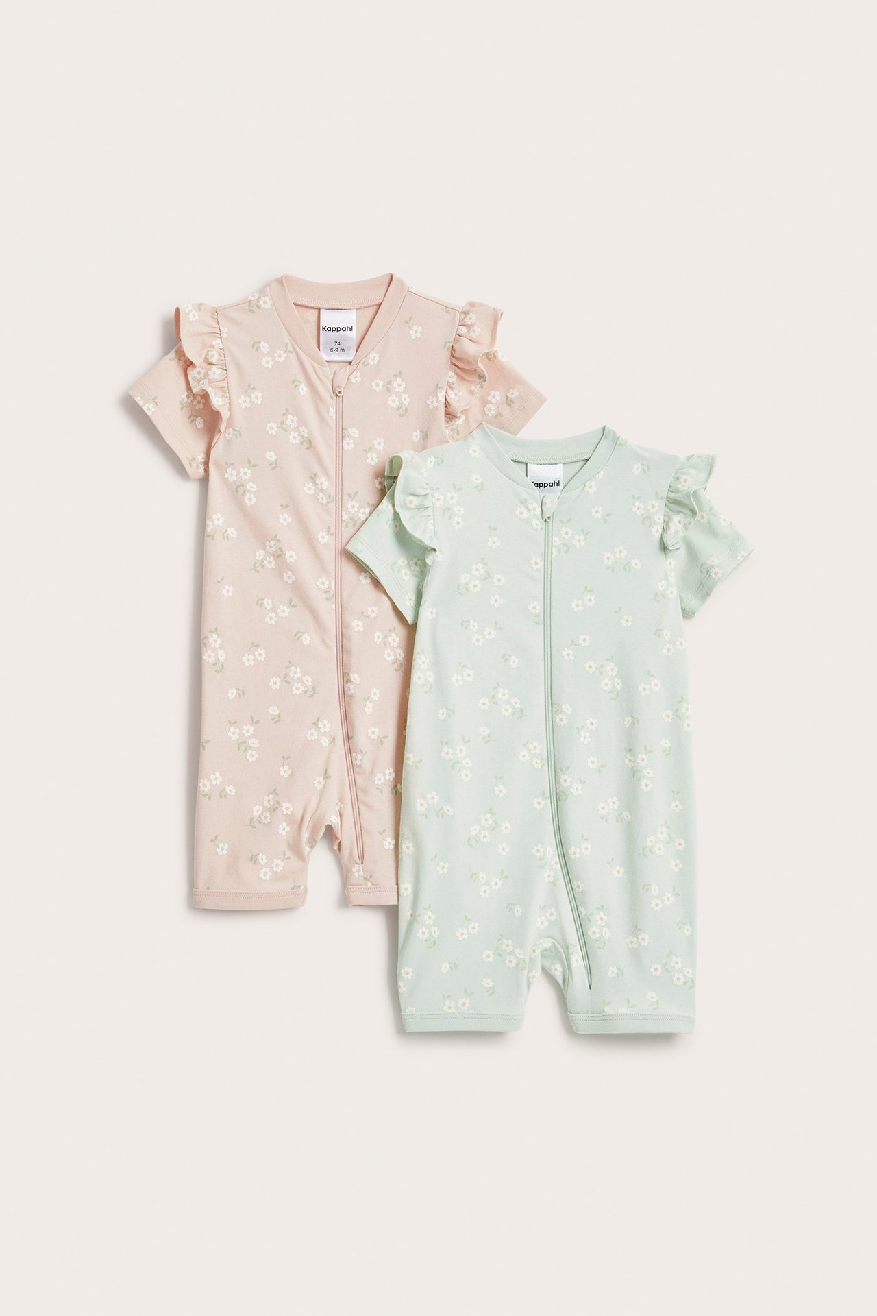 Widok z przodu: Dwa pajacyki niemowlęce; różowy i jasnozielony, krótkie rękawy, kwiaty, falbanki na ramionach.