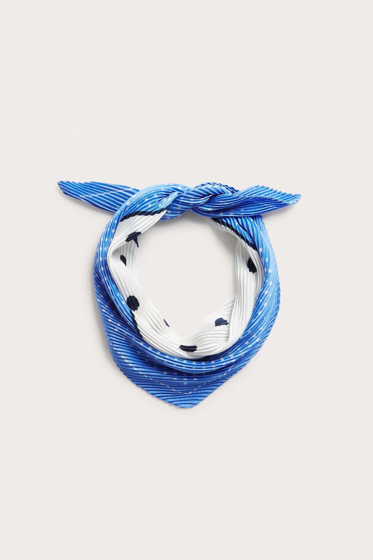 Lähikuva laskostetusta sinivalkokuvioisesta polyesterihuivista, solmittuna.