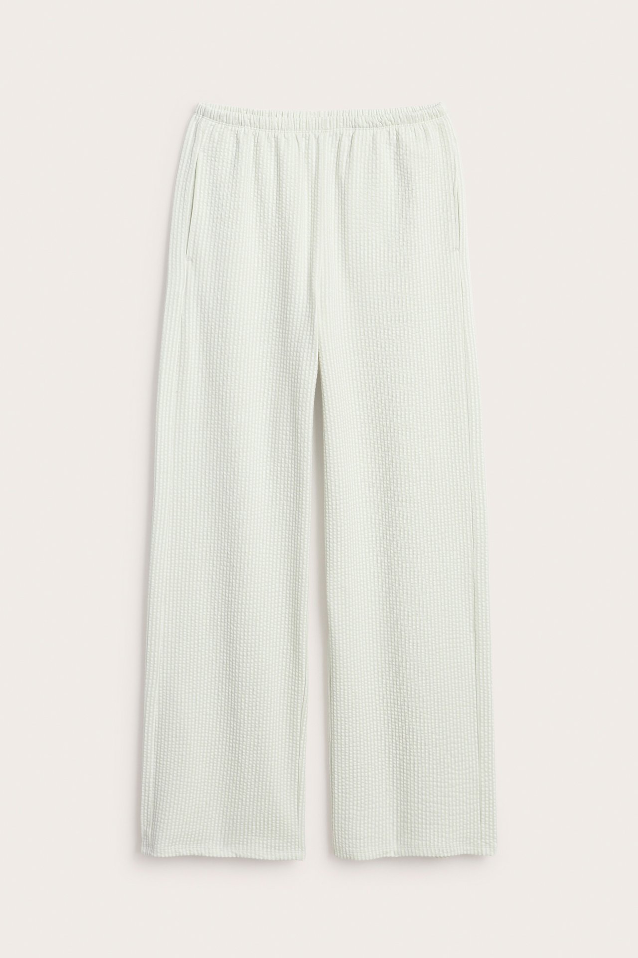 Frontvy av ljusgröna randiga bäckebölja pyjamasbyxor med resårmidja och sidfickor.