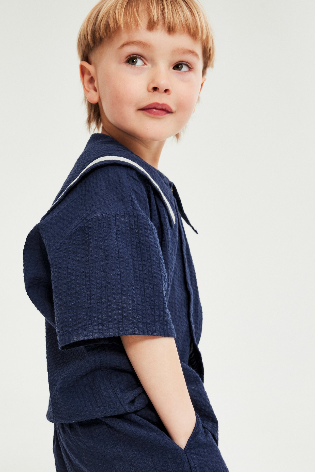 Barn i blå seer-sucker sett med skjorte og shorts, kort erme, knapper, krage, justerbar midje.