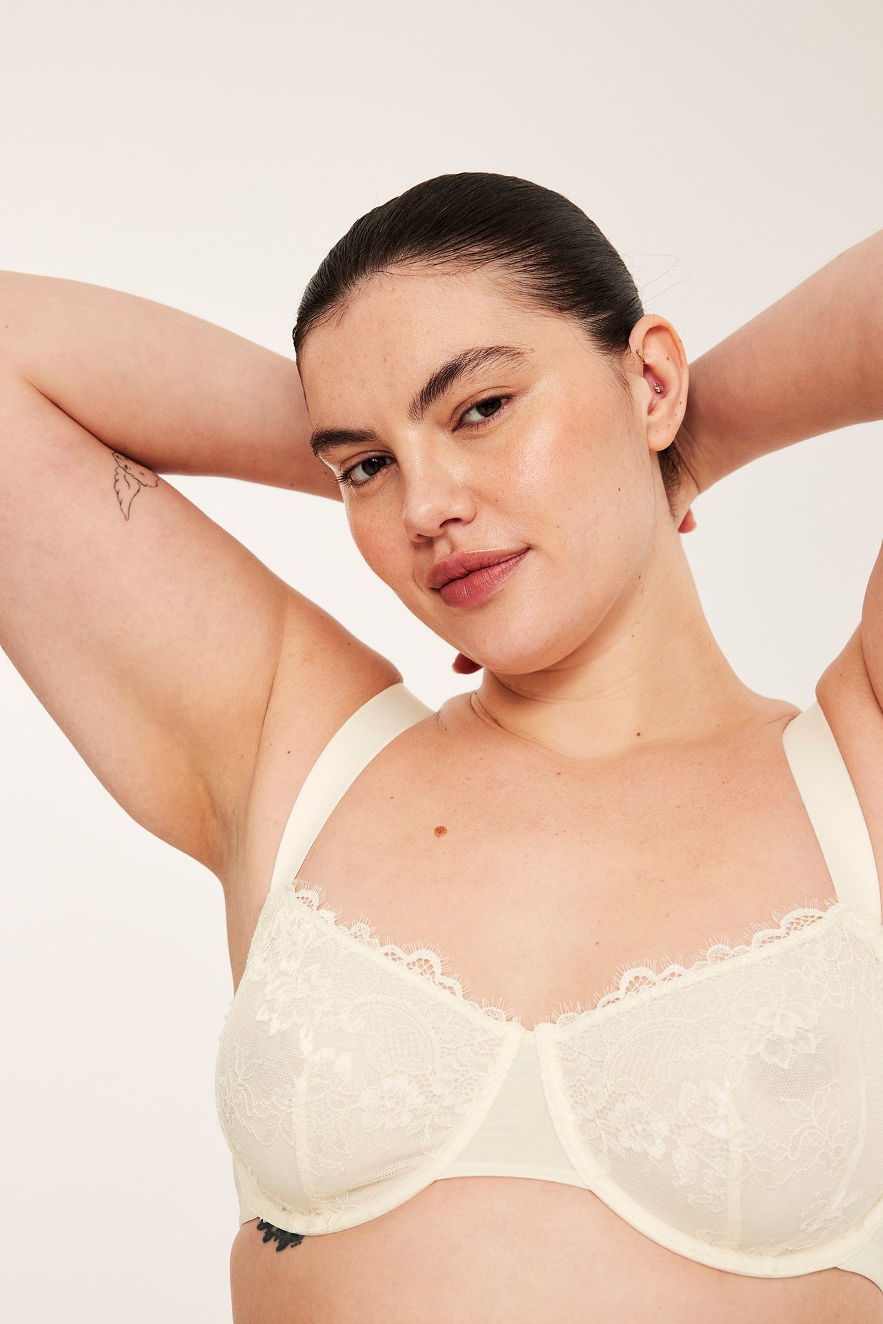 Nærbilde forfra av en kvinne som har på seg en offwhite blonde-BH med spiler og fine frynser.