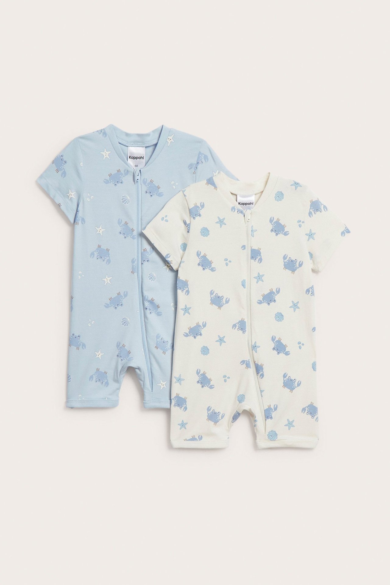 Dwa rampersy niemowlęce: jasnoniebieski i ecru, z krótkim rękawem, nadrukiem krabów i zamkiem.