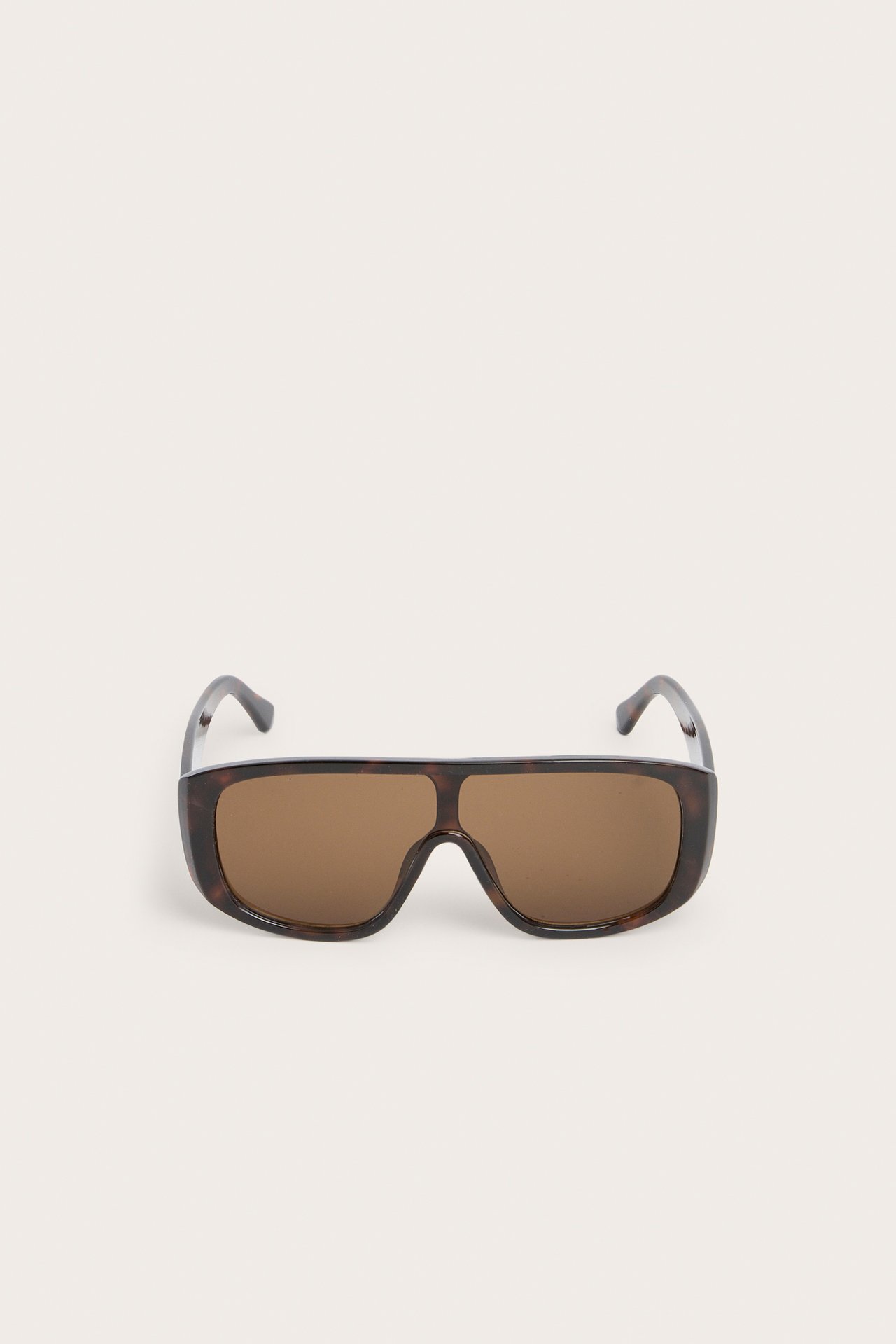 Framifrån av stora bruna mönstrade solglasögon i plast.