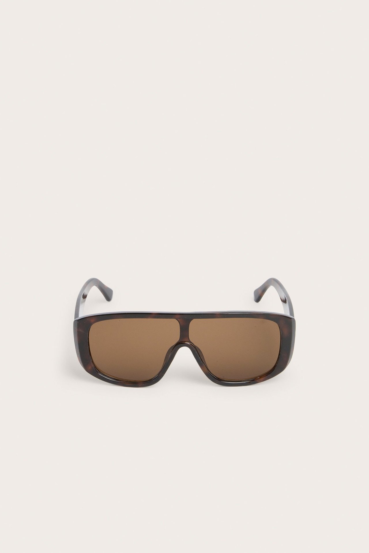 Edestä suuret ruskeat kuviolliset muoviset aurinkolasit.