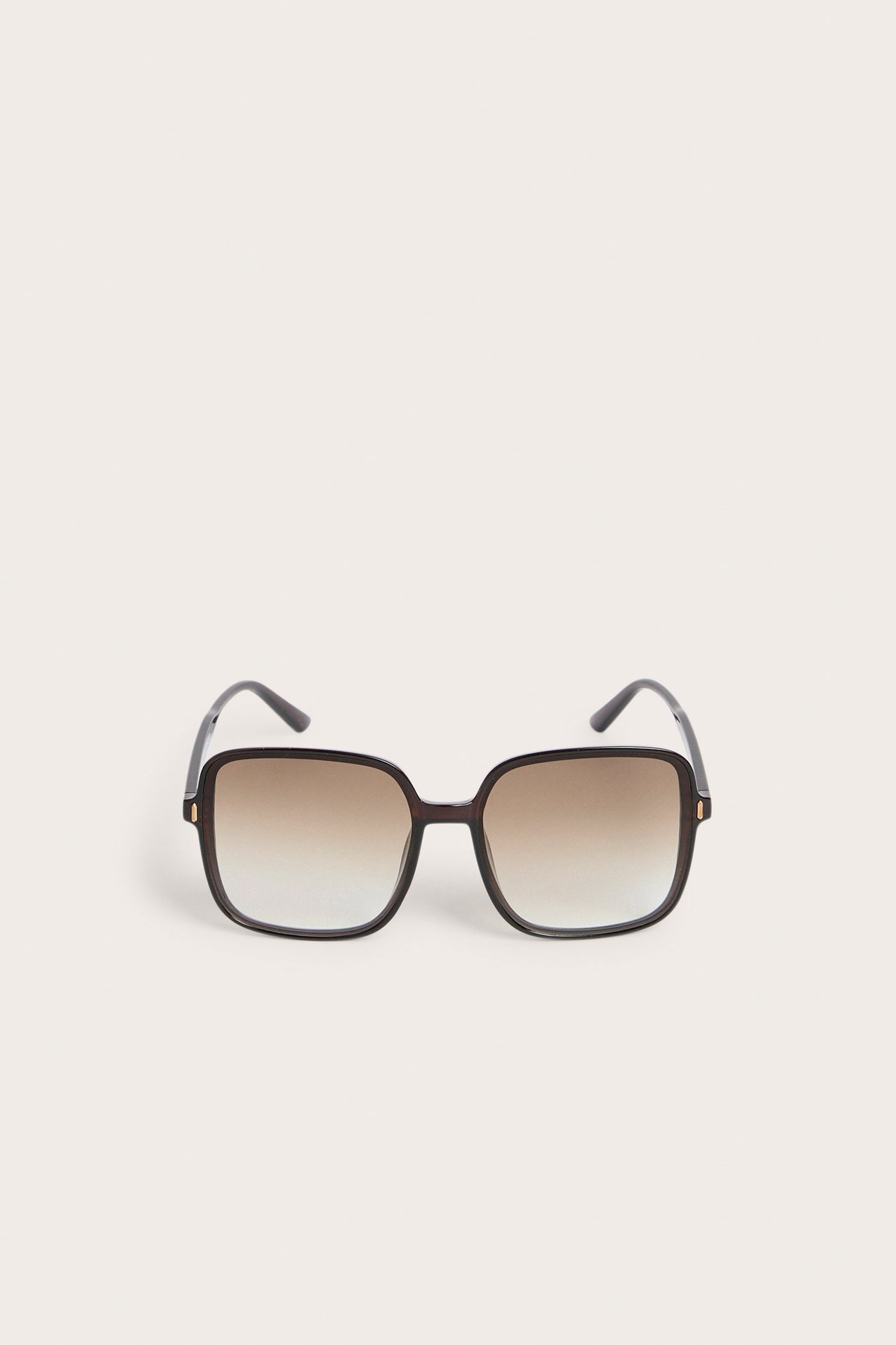 Edestä mustat neliönmuotoiset muoviset aurinkolasit ruskeilla liukuvärilinsseillä.