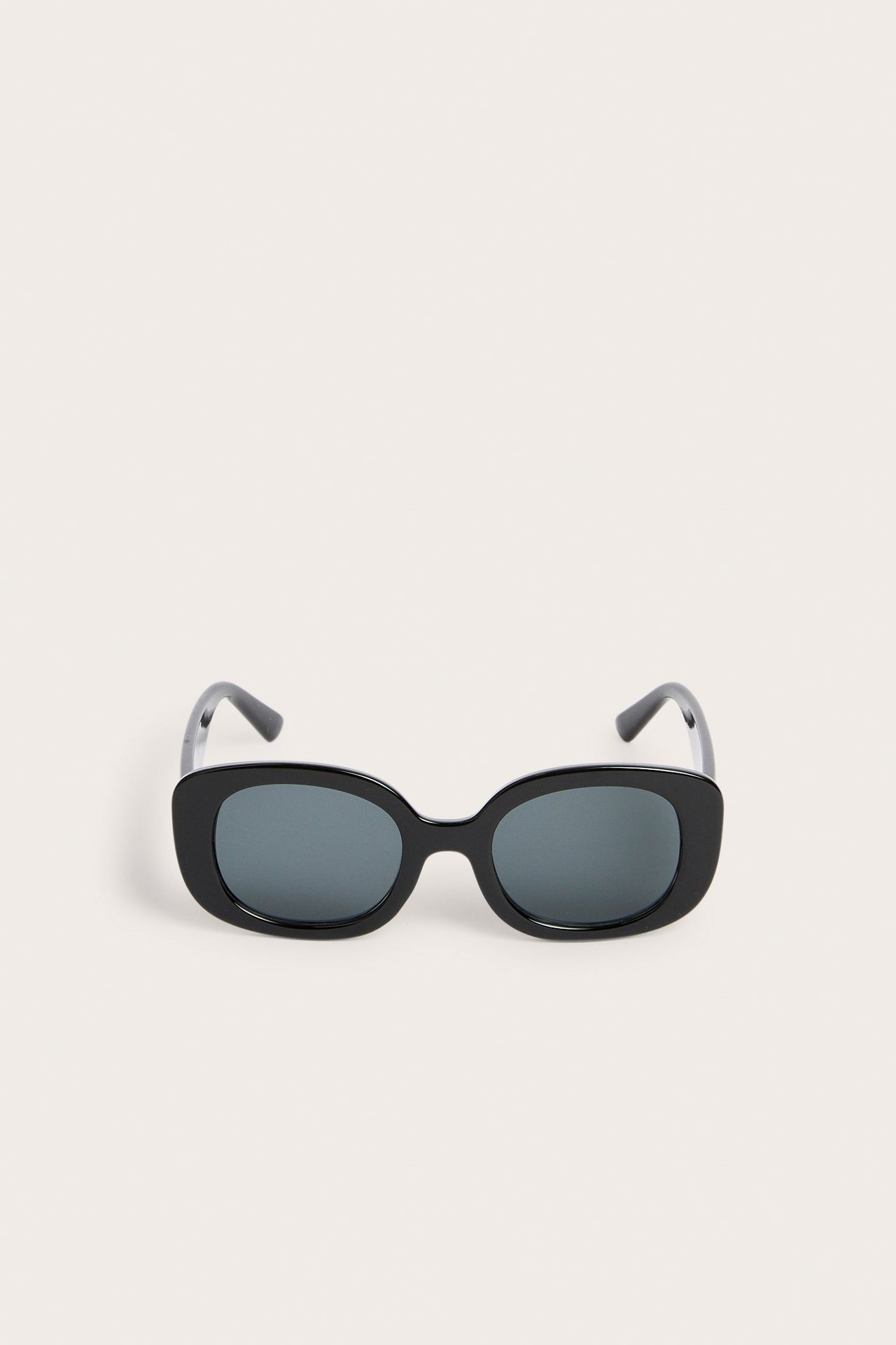 Frontvisning av svarte rektangulære solbriller i plast med mørke linser.