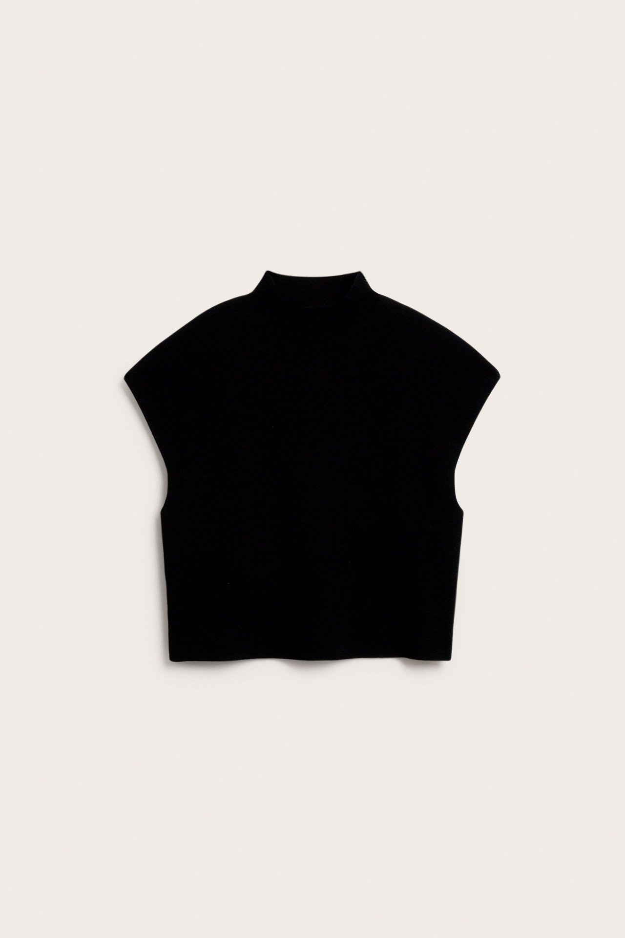 Edestäpäin, musta neuleliivi pystykauluksella ja lyhyillä hihoilla.