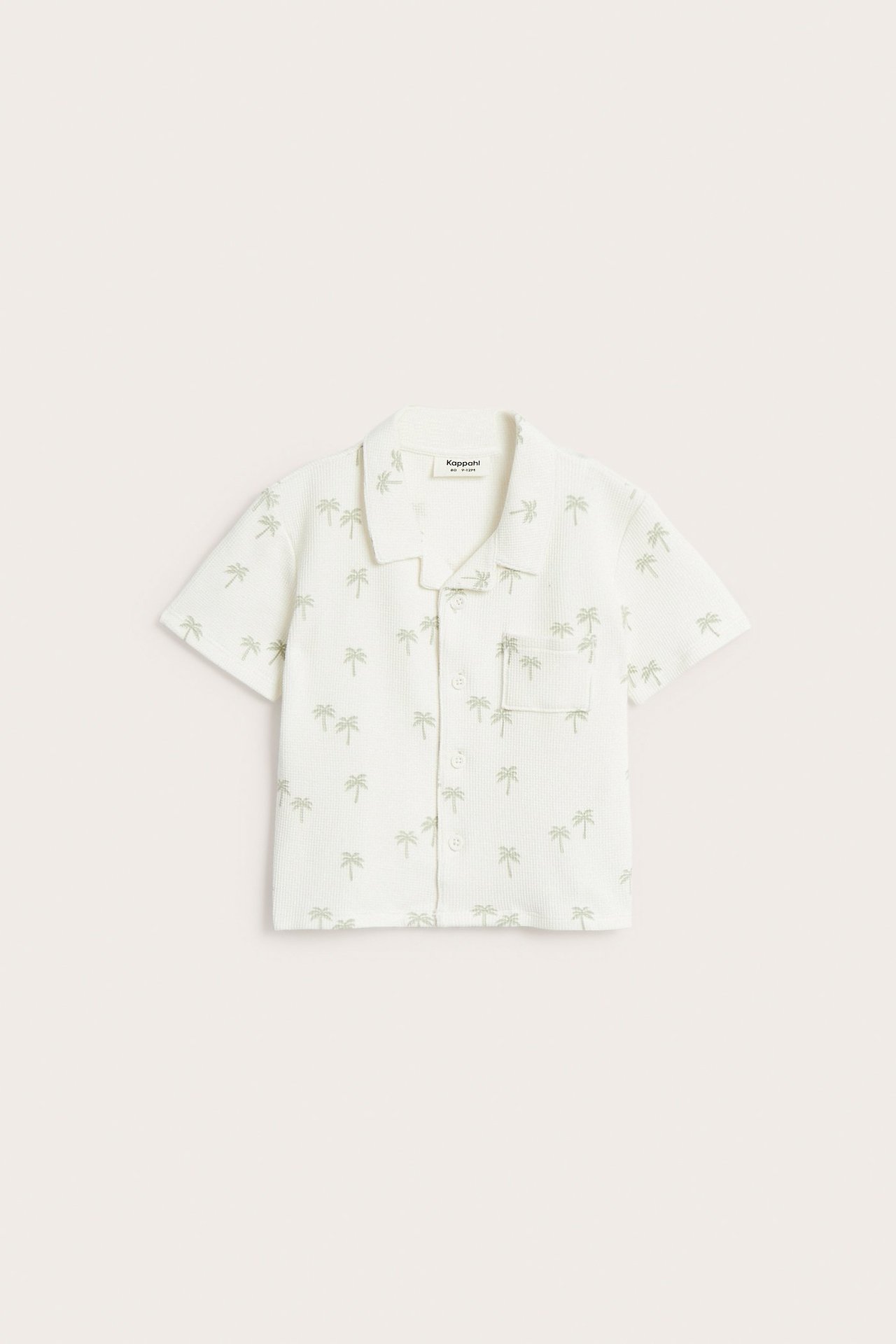 Ecru koszula niemowlęca wafelkowa z krótkim rękawem, zielone palmy, kieszeń. Widok z przodu.