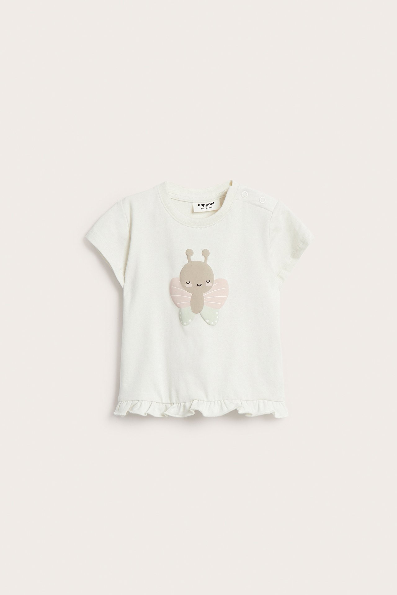 Edestä: Luonnonvalkoinen vauvan lyhythihainen t-paita perhoskuviolla, röyhelöllä ja olkanäppäimillä.