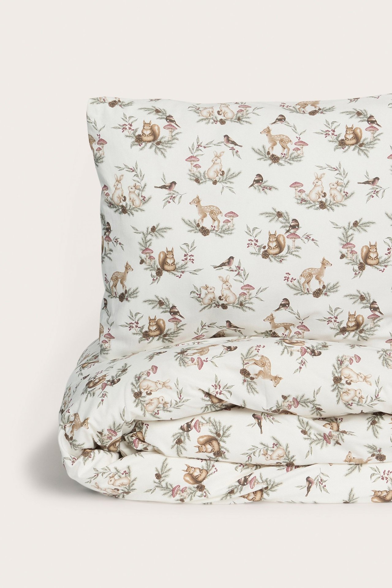 Widok z przodu wzorzystego bawełnianego kompletu pościeli w kolorze ecru z motywem leśnych zwierząt.
